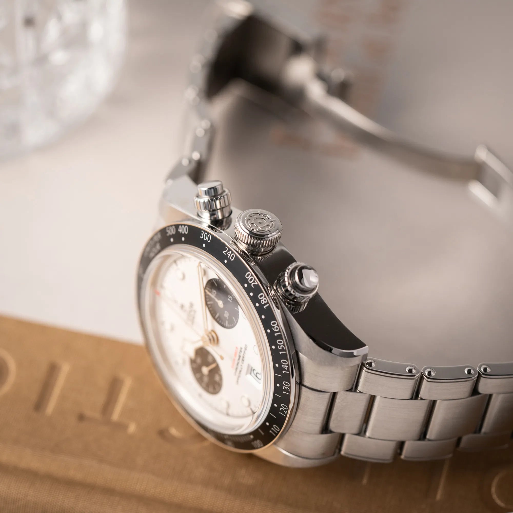 Produktfotografie von dem Tudor Black Bay Chronograph 79360N mit dem Panda-Zifferblatt in weiß mit schwarzen Totalisatoren zeigt die seitliche Gehäuseflanke mit Blick auf die Aufzugskrone und die Chronograph-Drücker