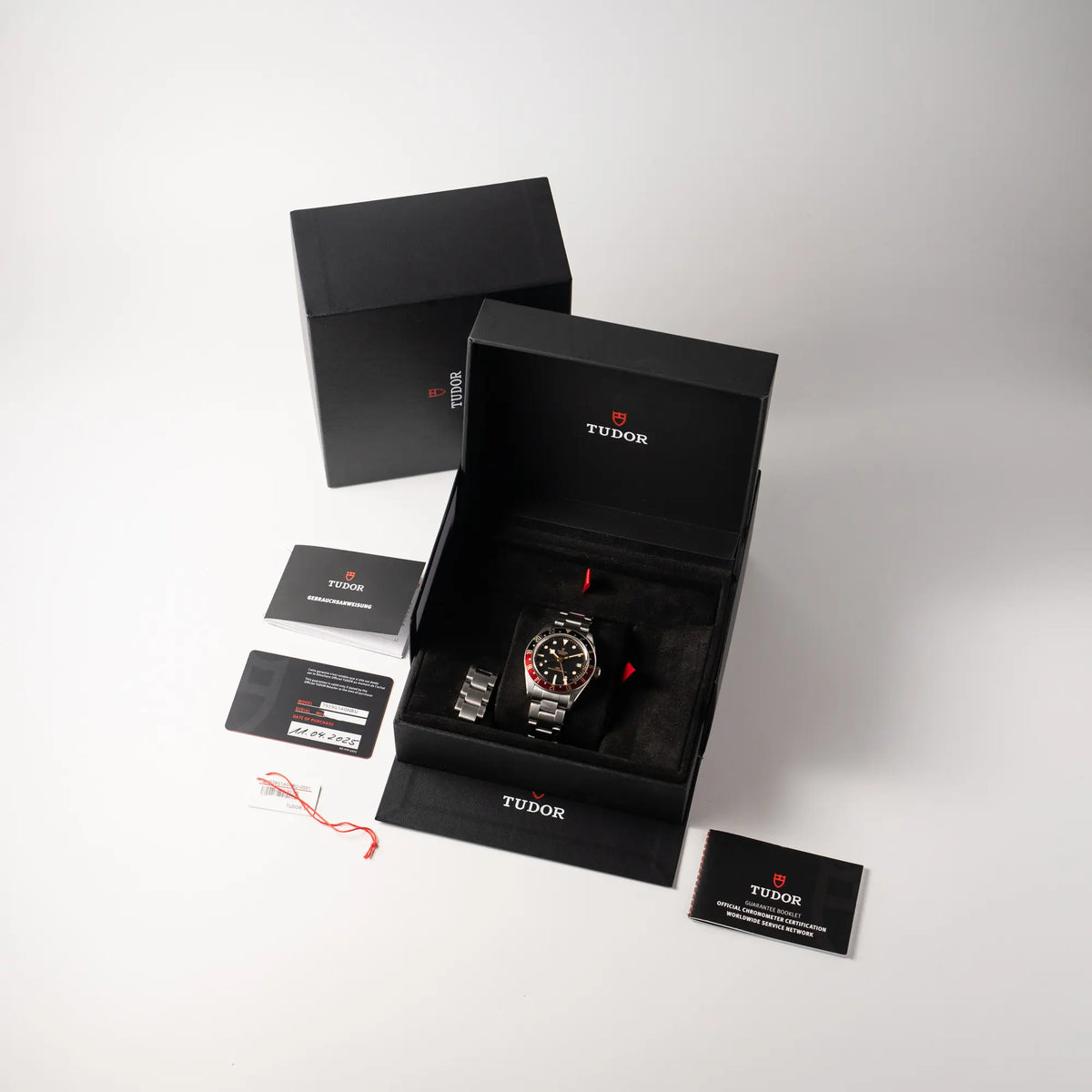 Lieferumfang zu der Tudor BlackBay GMT Coke der Referenz 7939G1A0NRU mit der schwarz-roten Lünette und bronzefarbenen Details am Edelstahlarmband, bestehend aus Box mit Umkarton, Booklets, Hangtag und originaler Garantiekarte
