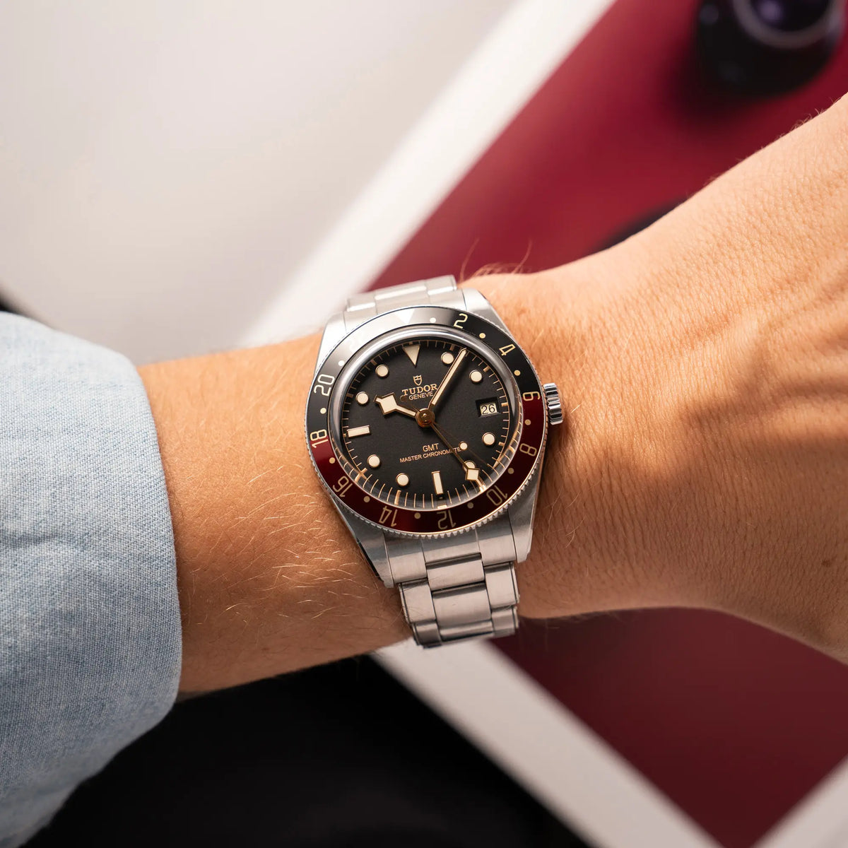 Mann trägt die Tudor BlackBay GMT Coke der Referenz 7939G1A0NRU mit der schwarz-roten Lünette und bronzefarbenen Details am Edelstahlarmband für einen Wristshot an seinem Handgelenk