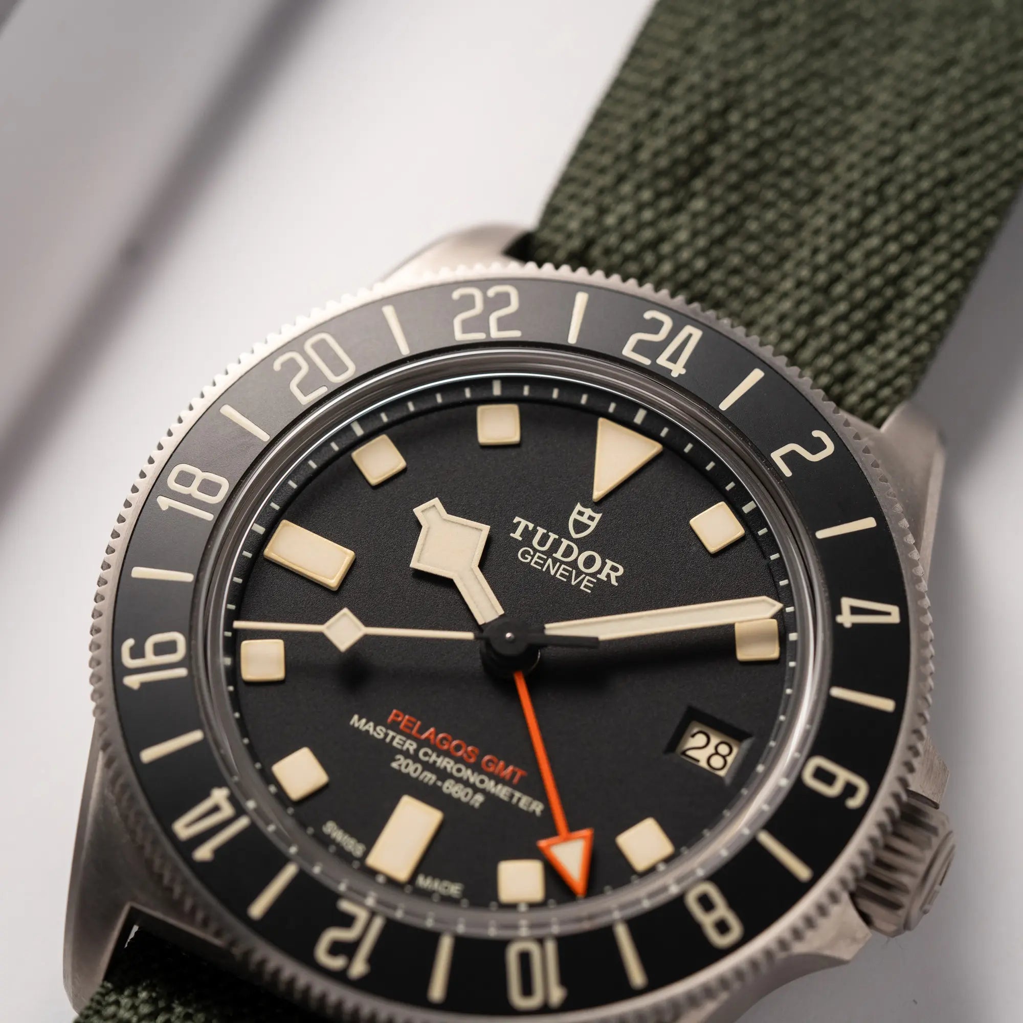 Detailaufnahme der Tudor Pelagos GMT Military der Referenz M2542G257NU-0002 mit Titan-Gehäuse und schwarzem Zifferblatt an einem olivgrünen Nato-Strap