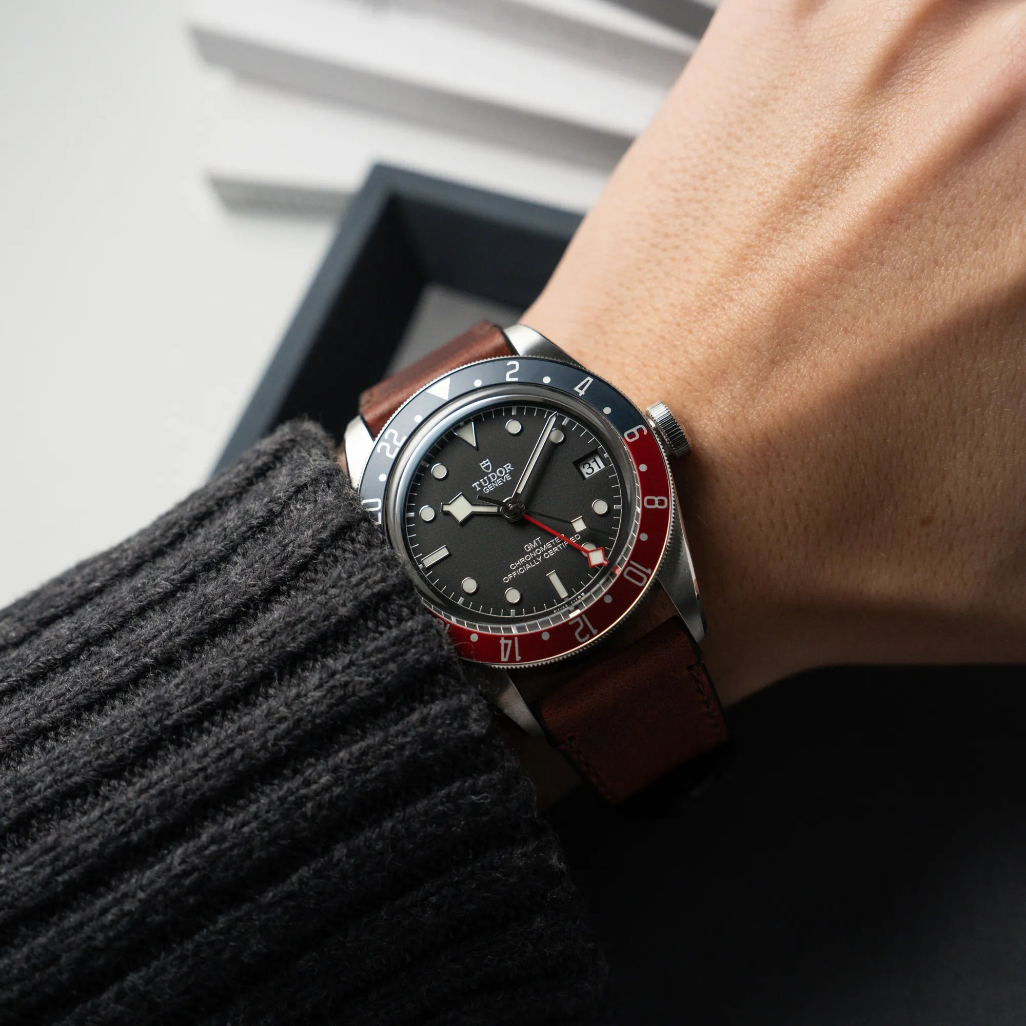 Wristshot mit der Tudor Black Bay Pepsi mit der Referenz 97830RB am braunen Lederband im Neuzustand