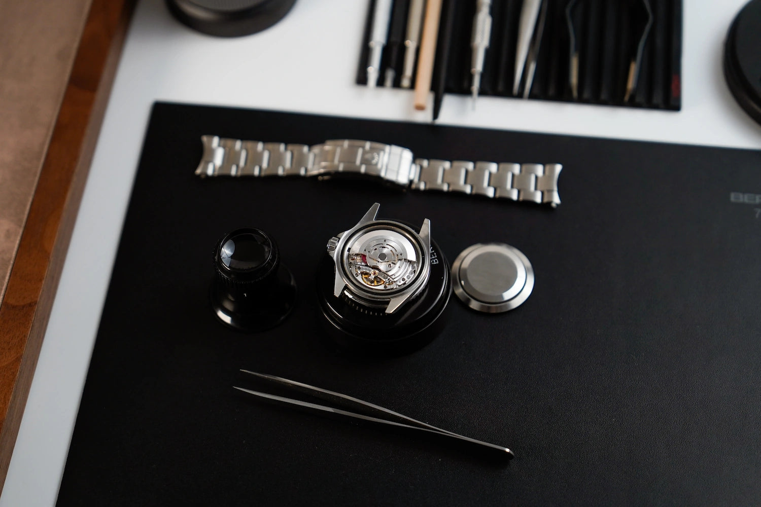 Gehäuse einer Rolex Uhr liegt ohne Band und Gehäusedeckel am Arbeitsplatz des Uhrmachers für eine Reparatur