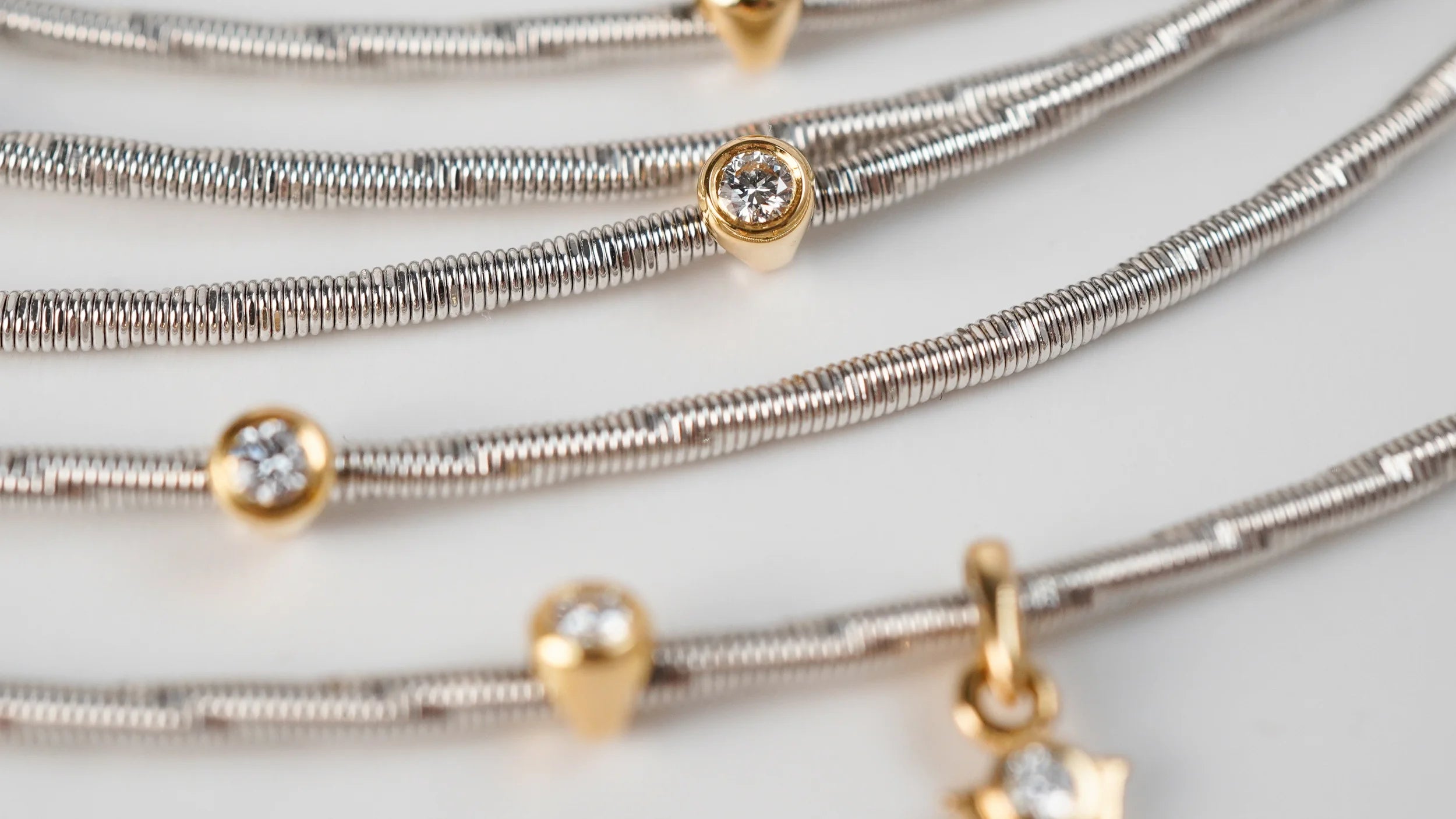 Zertifizierter Schmuck aus zweiter Hand: das Wellendorg Collier in Weißgold mit Gelbgolg-gefassten Diamanten als Detail