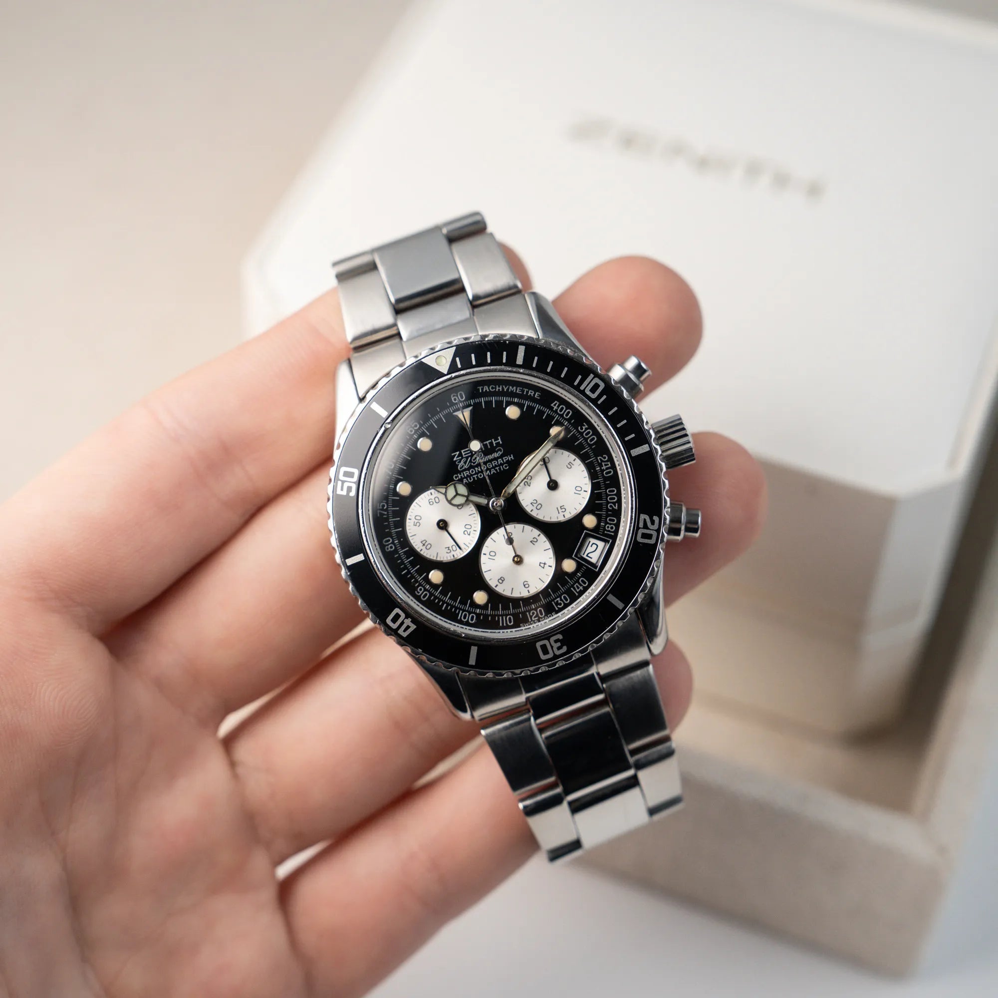 Mann hält den Zenith El Primero Chronograph aus 1993 mit schwarzem Zifferblatt und silbernen Totalisatoren in seiner Hand und präsentiert die Uhr