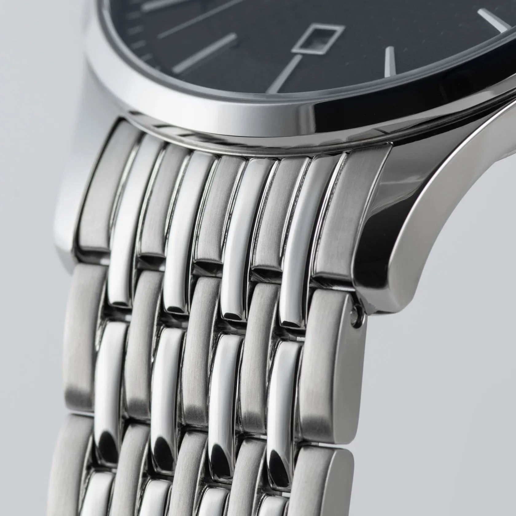 Detailaufnahme zeigt die Lünette und den Bandanstoß der Jacques Lemans 1-2193H Herrenuhr aus der London-Kollektion mit blauem Zifferblatt am feingliedrigen Edelstahl-Armband