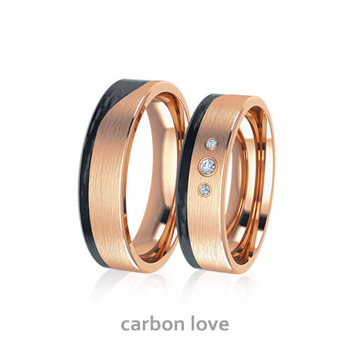 Produktfotografie des Trauringpaars Carbon Love in Rosegold und Carbon mit drei Diamanten auf dem Damenring
