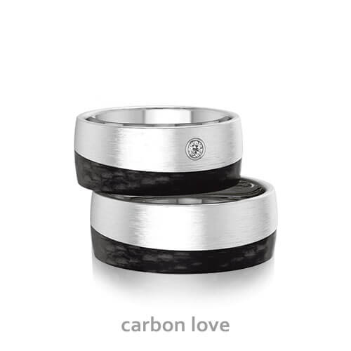 Produktfotografie des Trauringpaars Carbon Love in Weißgold und Carbon. it einem Diamanten im Damenring