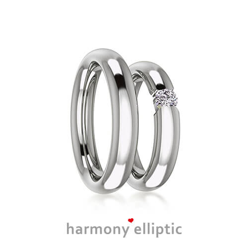 Produktfotografie des Trauringpaars Harmony Elliptic in Weißgold, mit einem großen Diamant im Damenring