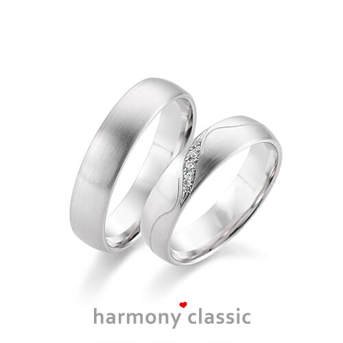 Produktfotografie des Trauringpaars Harmony Classic in Weißgold mit Diamanten und Verzierungen im Damenring