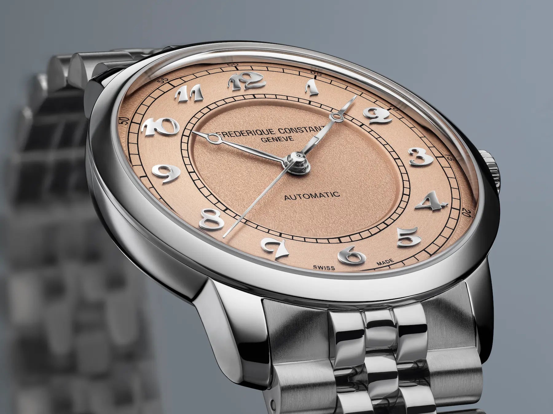 Detailaufnahme der Frederique Constant "Classics Premiere" Armbanduhr FC-301SALB6B mit lachsrosa-farbenen Zifferblatt zeigt die zwei verschiedenen Oberflächenstrukturen und arabischen Ziffern im klassischen Stil