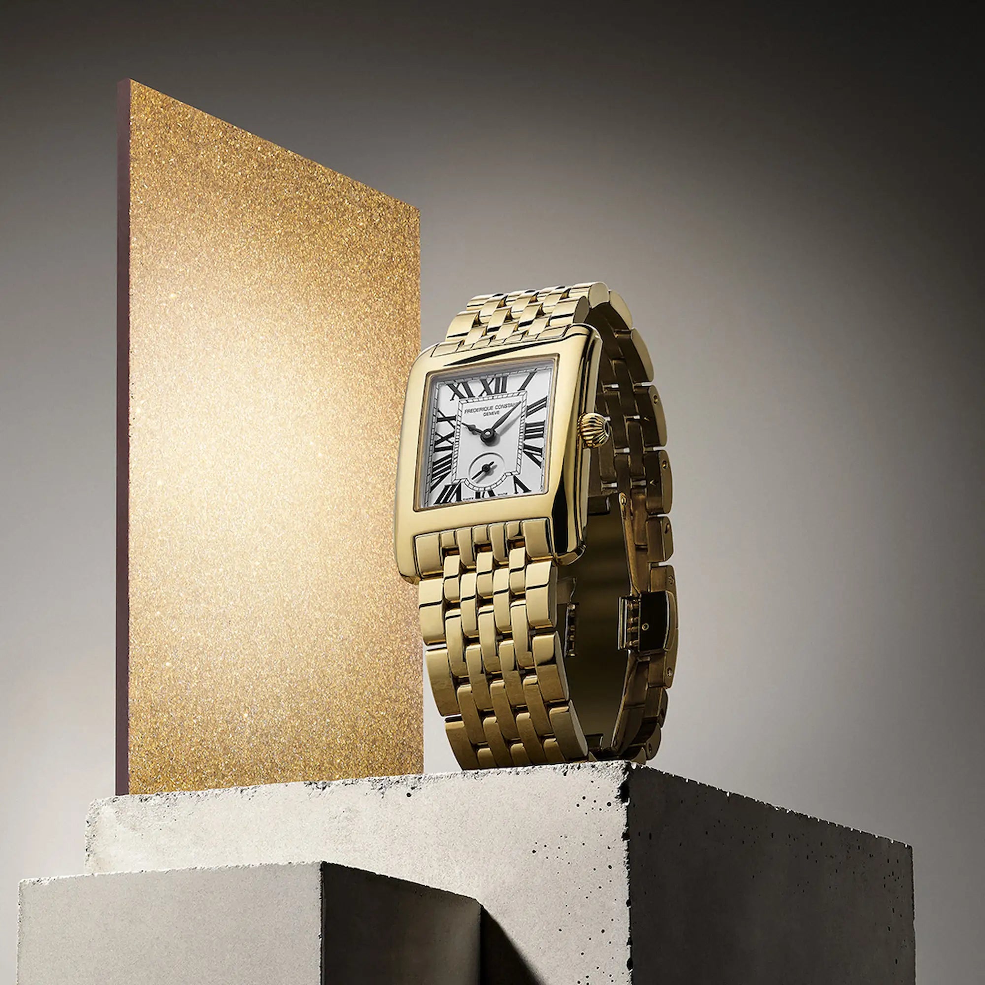 Produktfotografie der Frontale Ansicht der goldfarbenen Frederique Constant Classics Carree Small Seconds Armbanduhr mit rechteckigem Gehäuse im Art-Deco-Stil und römischen Indizes mit einem gold-glänzenden Zierelement
