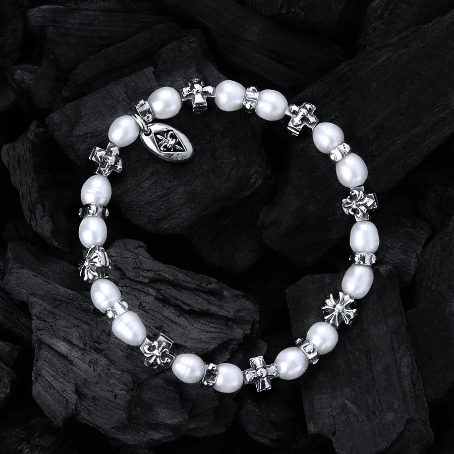 Fotografie des Elfcraft Armbands mit weißen Perlen und silbernen Kreuz-Elementen im Lilien-Design und Malteser-Kreuz-Design vor schwarzer Kohle
