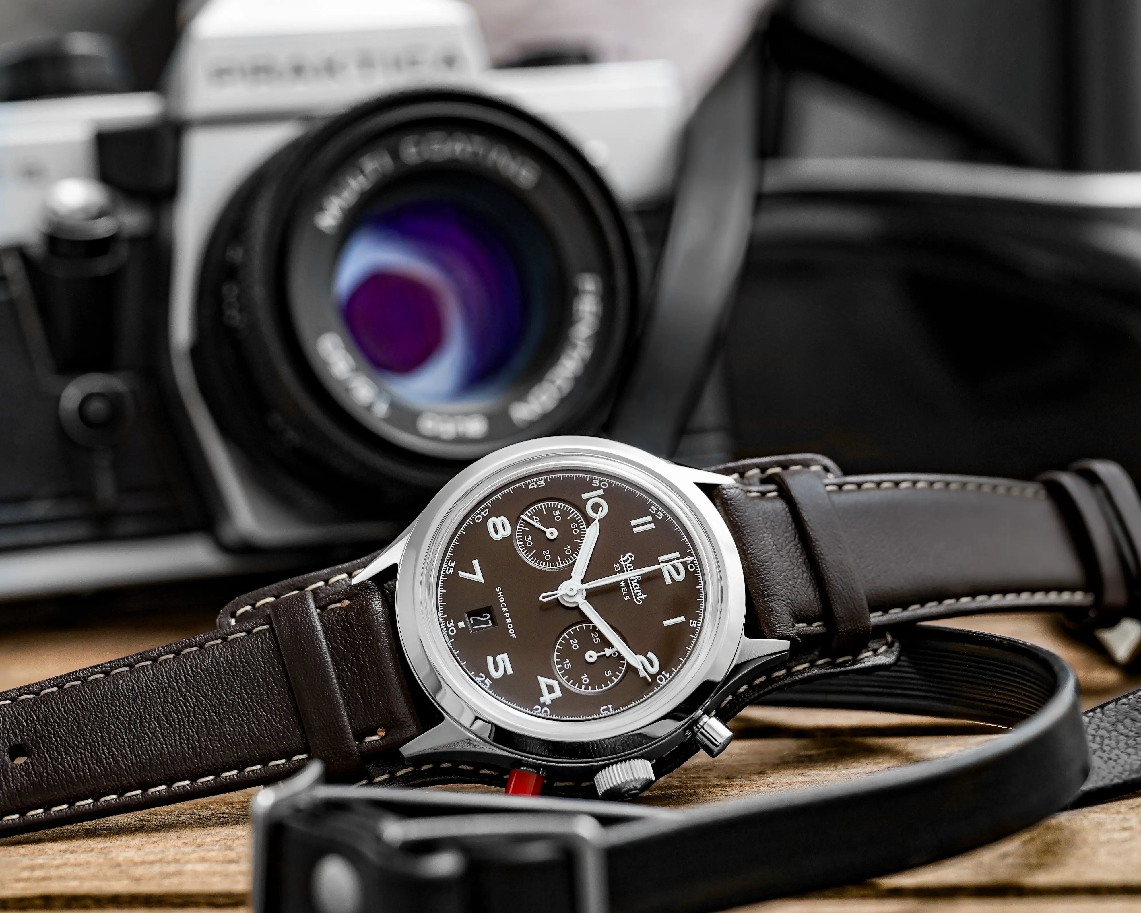 Produktfotografie der Hanhart 417 ES Mokka Limited Edition mit einem braunem Zifferblatt an einem passenden braunem Lederband mit Unterlage