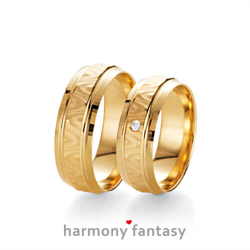 Produktfotografie des Trauringpaars Harmony Fantasy in Gelbgold, mit einem Diamant im Damenring