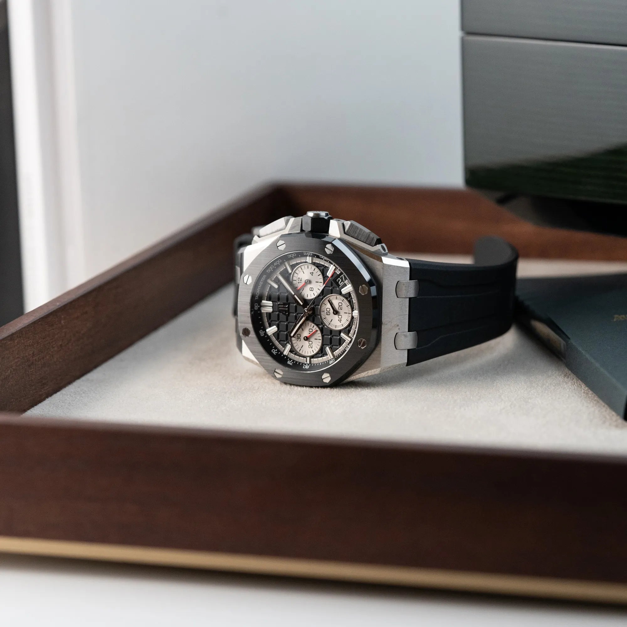 Produktfotografie des Audemars Piguet Royal Oak Chronograph 26420SO.OO.A002CA.01 mit schwarzem Zifferblatt und Lünette, während die Uhr auf einem Juwelierstablet liegt