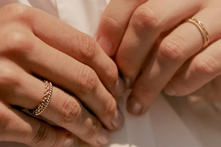 Detailaufnahme der Hände einer Frau trägt verschiedene, feine und verspielte Ringe für Damen an den Ringfingern