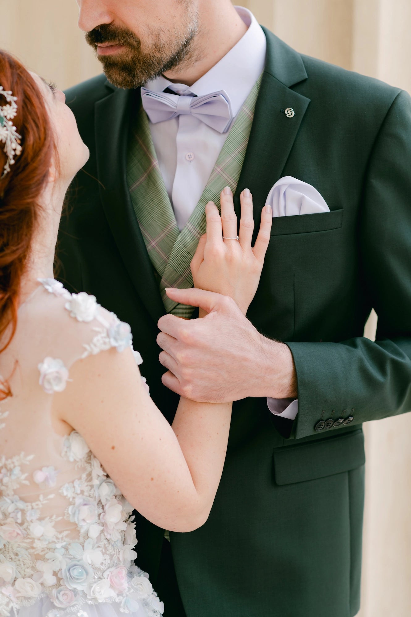 Braut legt am Hochzeitstag ihre Hand auf die Brust des Bräutigams in seinem grünen Anzug
