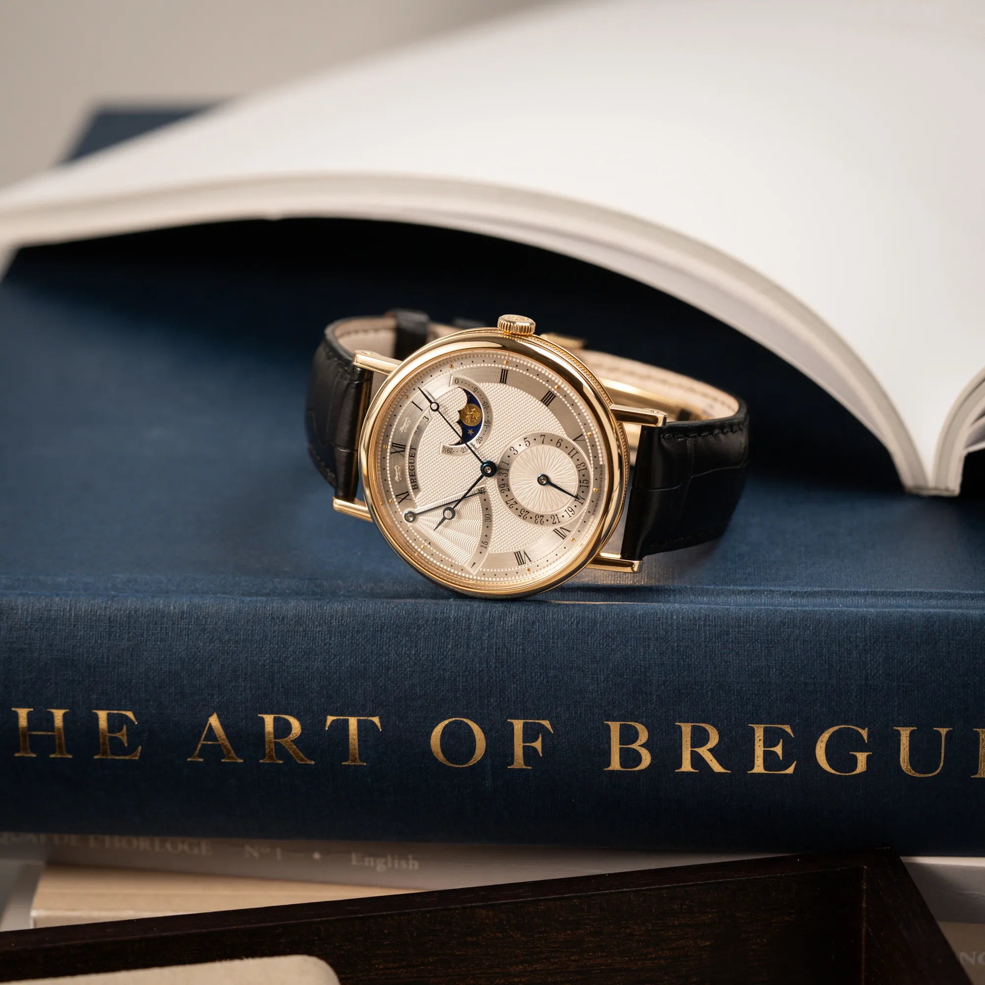 Produktfotografie als Titelbild für die Breguet Classique 7137BA mit einem Gelbgoldgehäuse in klassischer Form mit einem silbernen Zifferblatt mit jeweils einem anderen handgefertigten Guilloche-Muster für jede Komplikation 