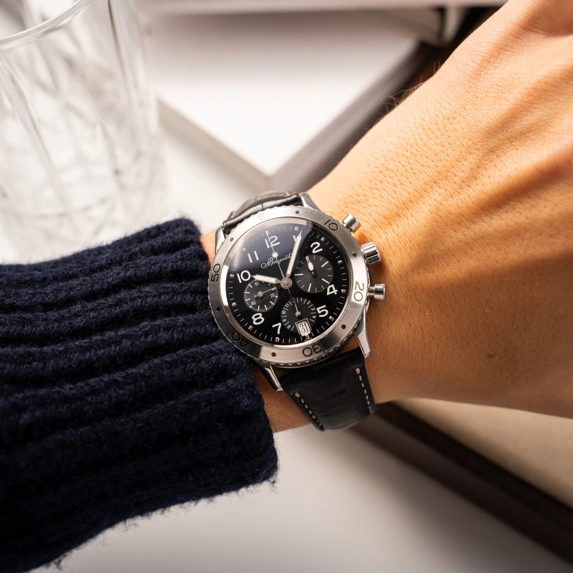 Wristshot mit der Breguet Type XX Aéronavale Transatlantique der Referenz 3820ST mit schwarzem Lack-Zifferblatt am originalen schwarzen Breguet-Lederband an einem Männerhandgelenk