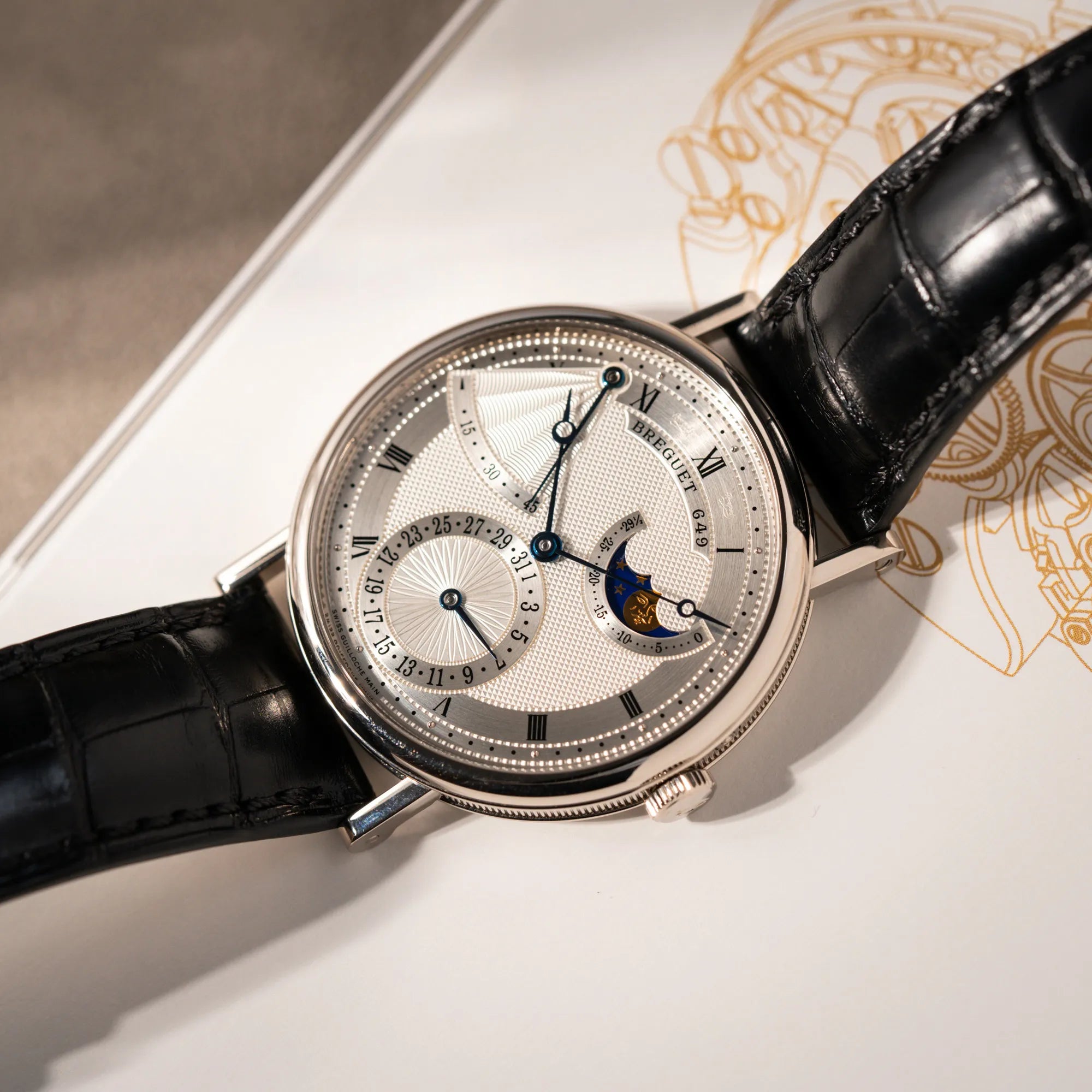 Produktfotografie als Titelbild der Breguet Classique Moonphase der Referenz 7137 in Weissgold mit 3-fach guillochiertem Zifferblatt und Mondphase-Anzeige