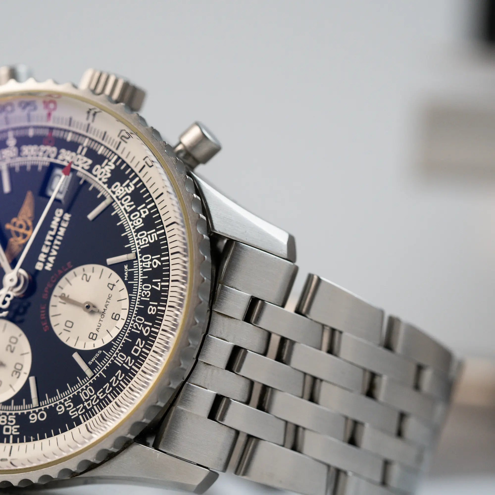 Detailaufnahme der Breitling Navitimer Fighters Edition mit schwarzem Zifferblatt und weißen Totalisatoren, sowie auf dme Bandanstoß