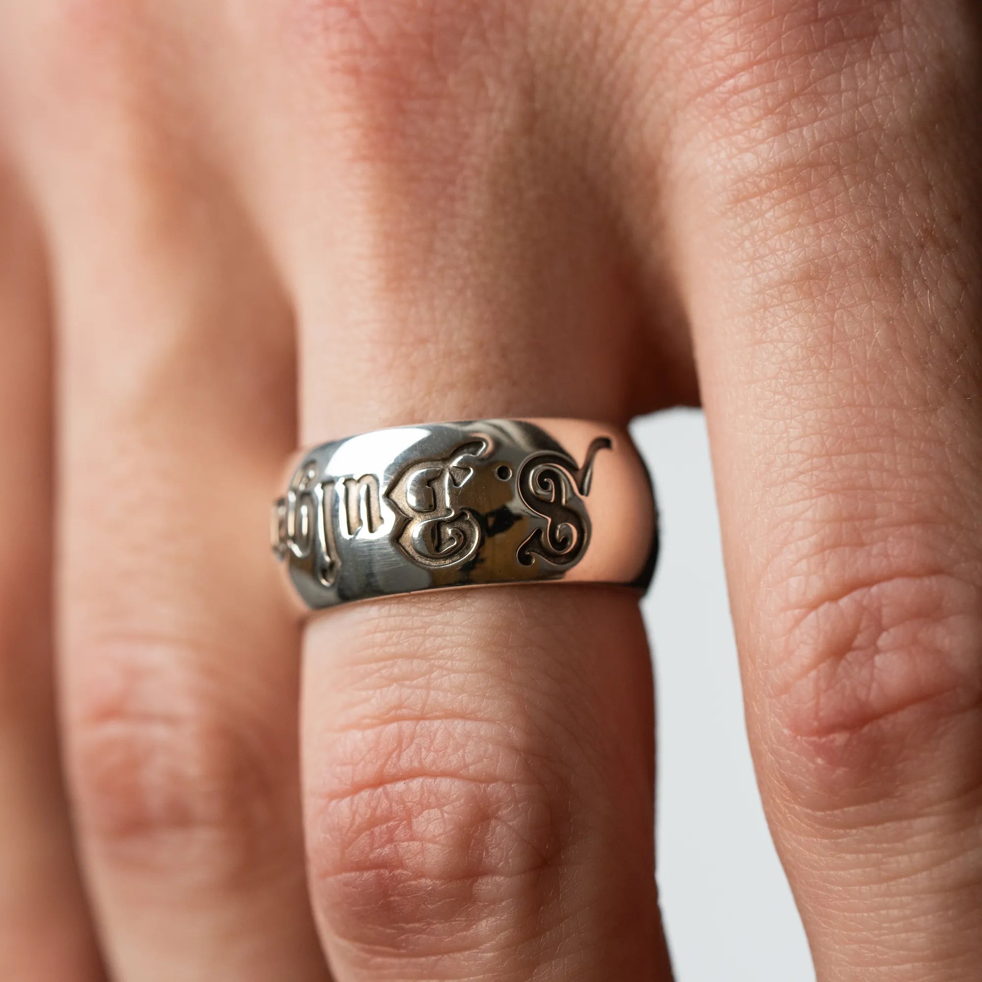 Mann trägt Bulgari Ring "Save The Children" in Silber an seinem Ringfinger