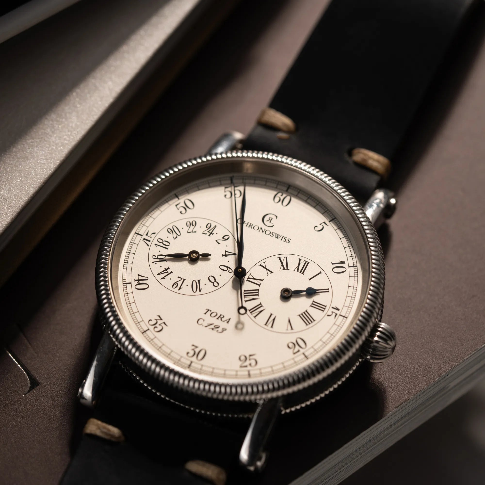 Detailaufnahme der Chronoswiss Regulator Tora C123 mit weißem Zifferblatt mit zwei symmetrisch angeordneten Hilfszifferblättern mit römischen Indizes