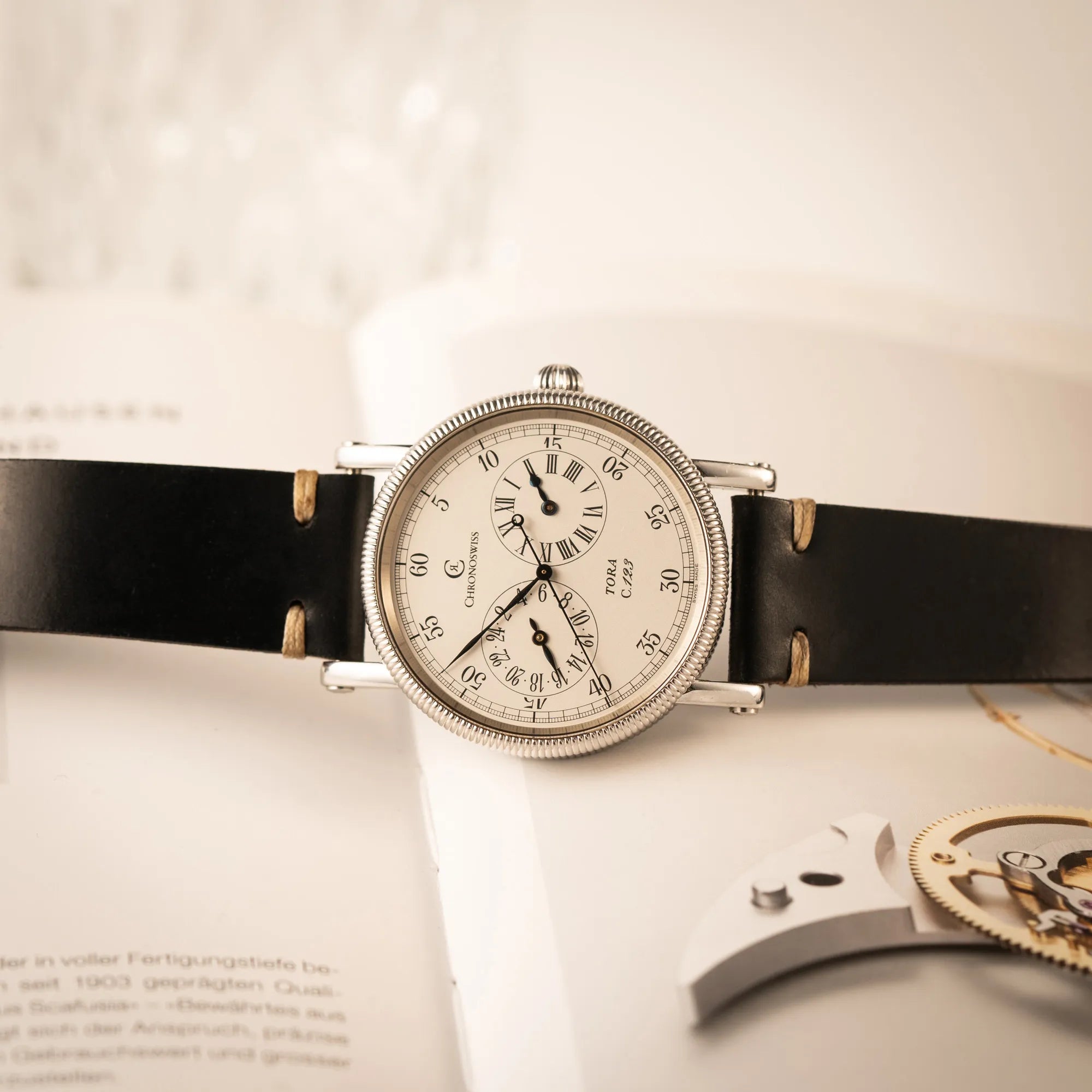 Produktfotografie der Chronoswiss Regulator Tora C123 mit weißem Zifferblatt mit zwei symmetrisch angeordneten Hilfszifferblättern mit römischen Indizes

