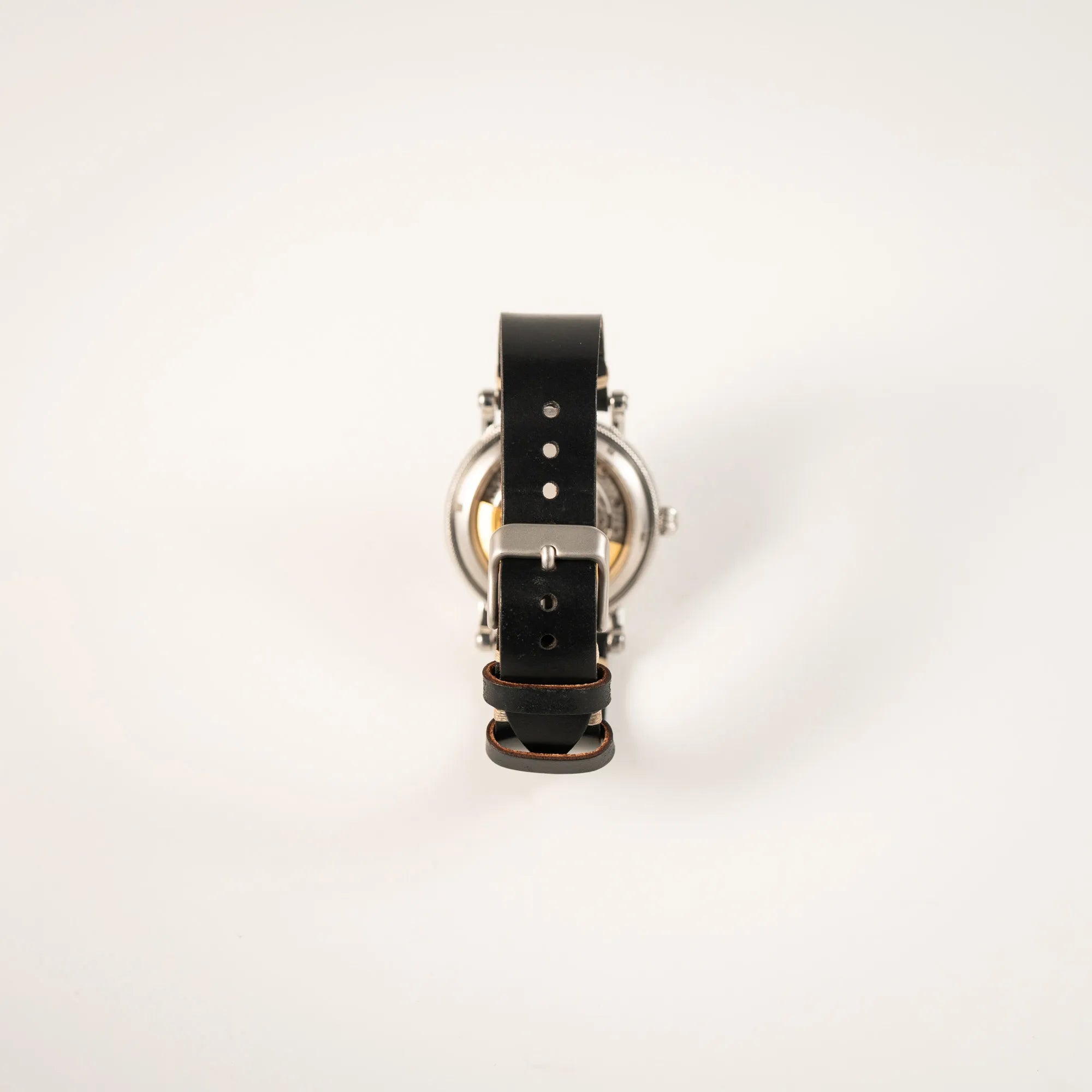 Blick auf das schwarze Lederband mit Dornschliesse der Chronoswiss Regulator Tora C123 mit weißem Zifferblatt mit zwei symmetrisch angeordneten Hilfszifferblättern mit römischen Indizes