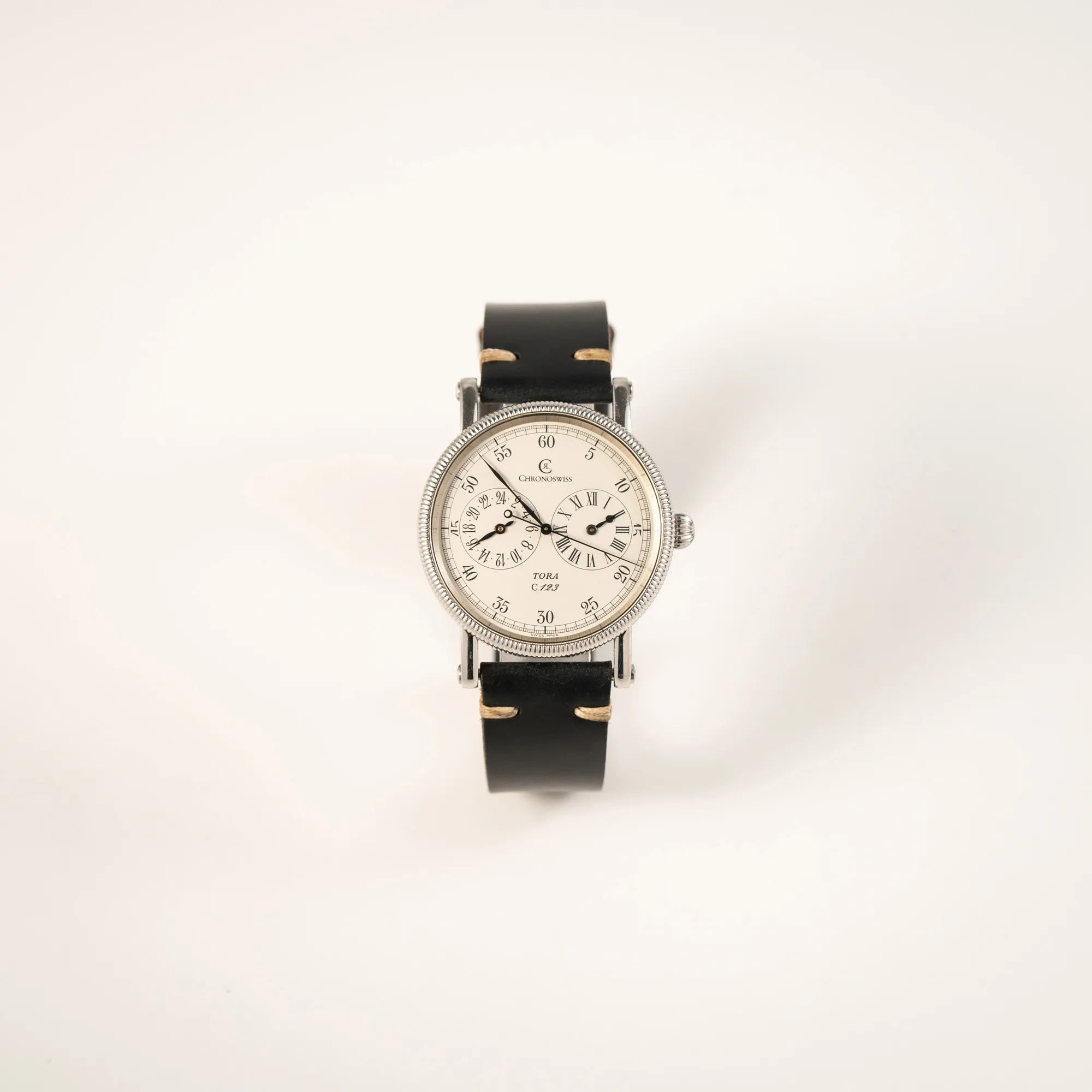 Frontale Ansicht der Chronoswiss Regulator Tora C123 mit weißem Zifferblatt mit zwei symmetrisch angeordneten Hilfszifferblättern mit römischen Indizes