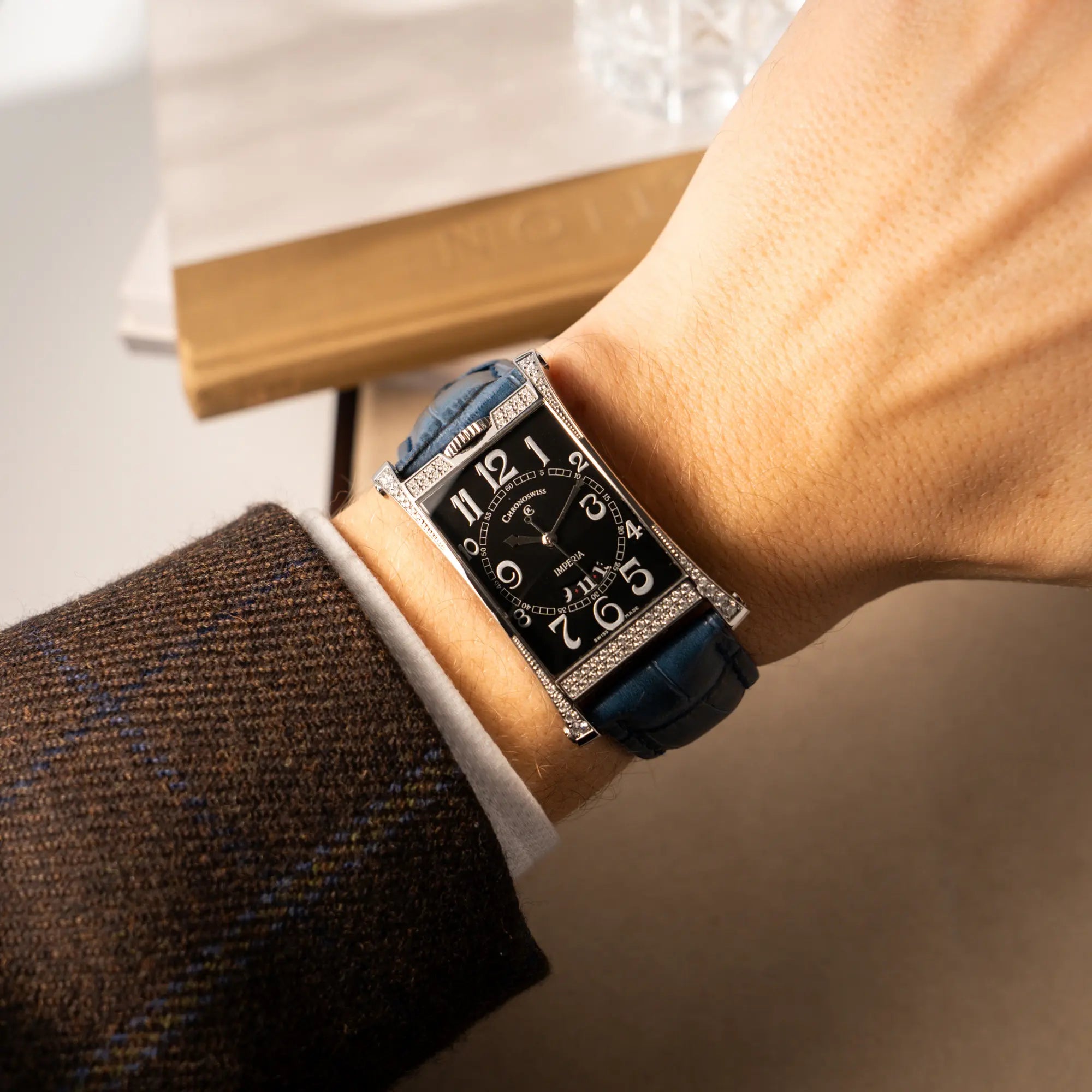 Wristshot mit der Chronoswiss Imperia Constanze mit diamantbesetzten-Stahlgehäuse mit schwarzem Zifferblatt an einem petrol-blauem Lederband