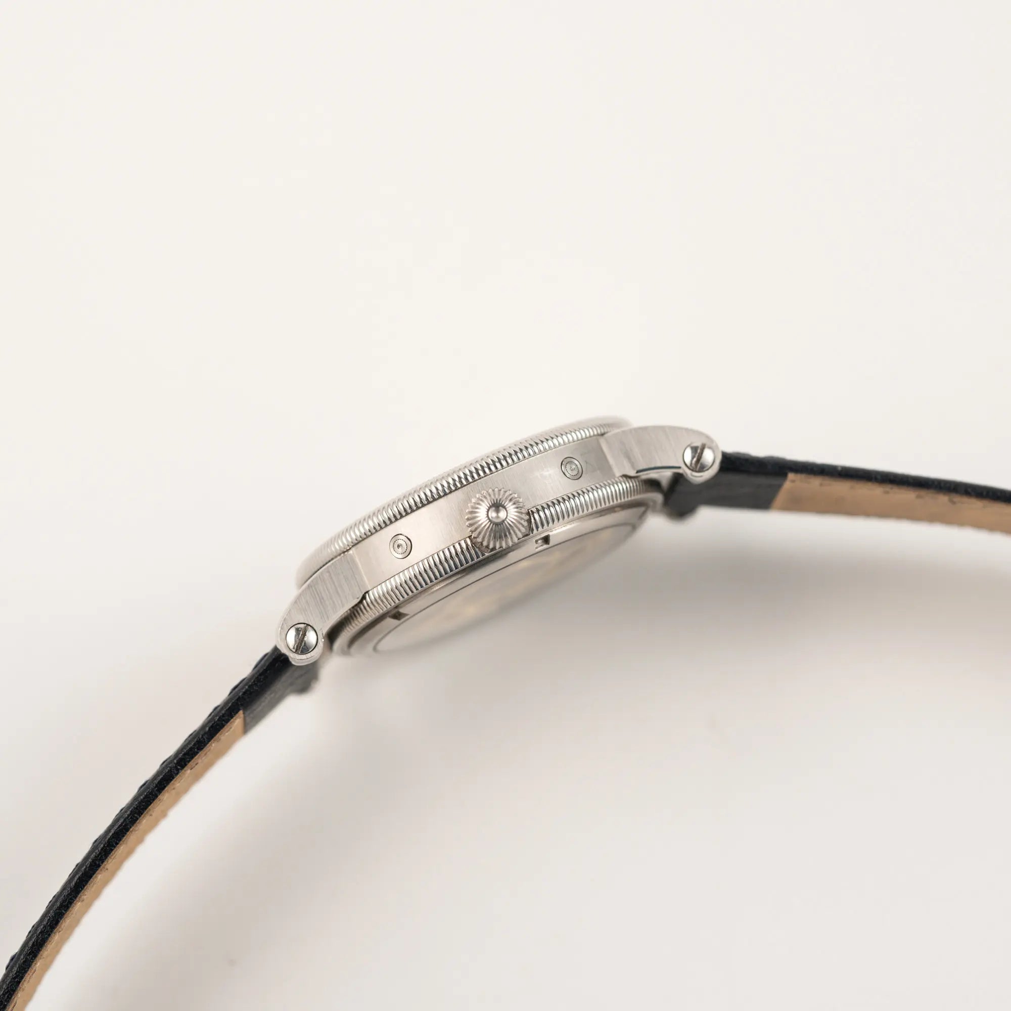 Seitliche Gehäuseflanke der Chronoswiss Klassic Luna Mondphase CH9323 mit silbernem, guillochiertem Zifferblatt mit Kalenderanzeige auf 12 Uhr und einer Mondphase-Anzeige bei 6 Uhr mit Blick auf die Aufzugskrone