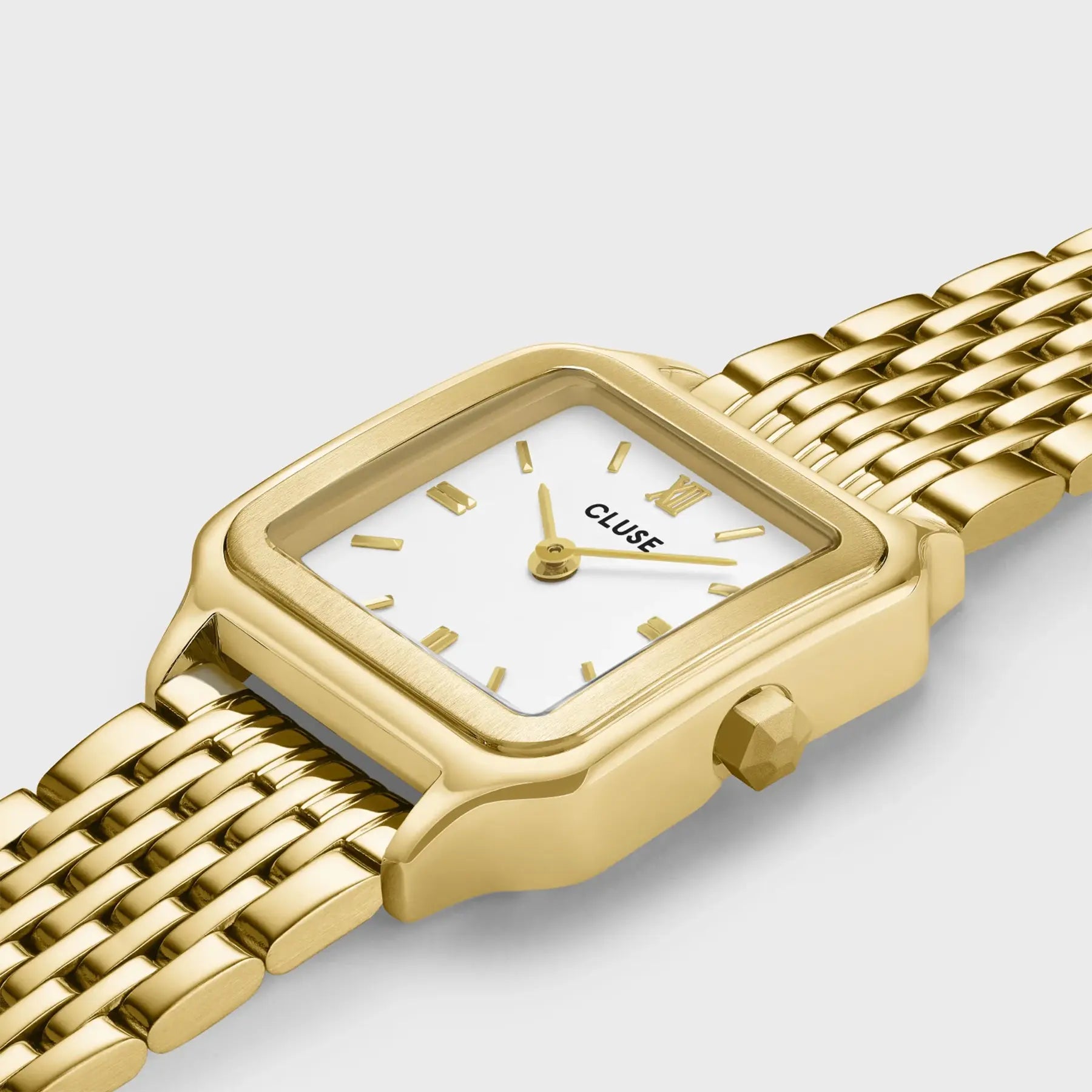 Leicht seitliche Ansicht der der goldfarbenen Cluse Damenuhr Gracieuse Petite der Referenz CW11815 mit weißem Zifferblatt an einem feingliedrigen goldfarbenem Armband