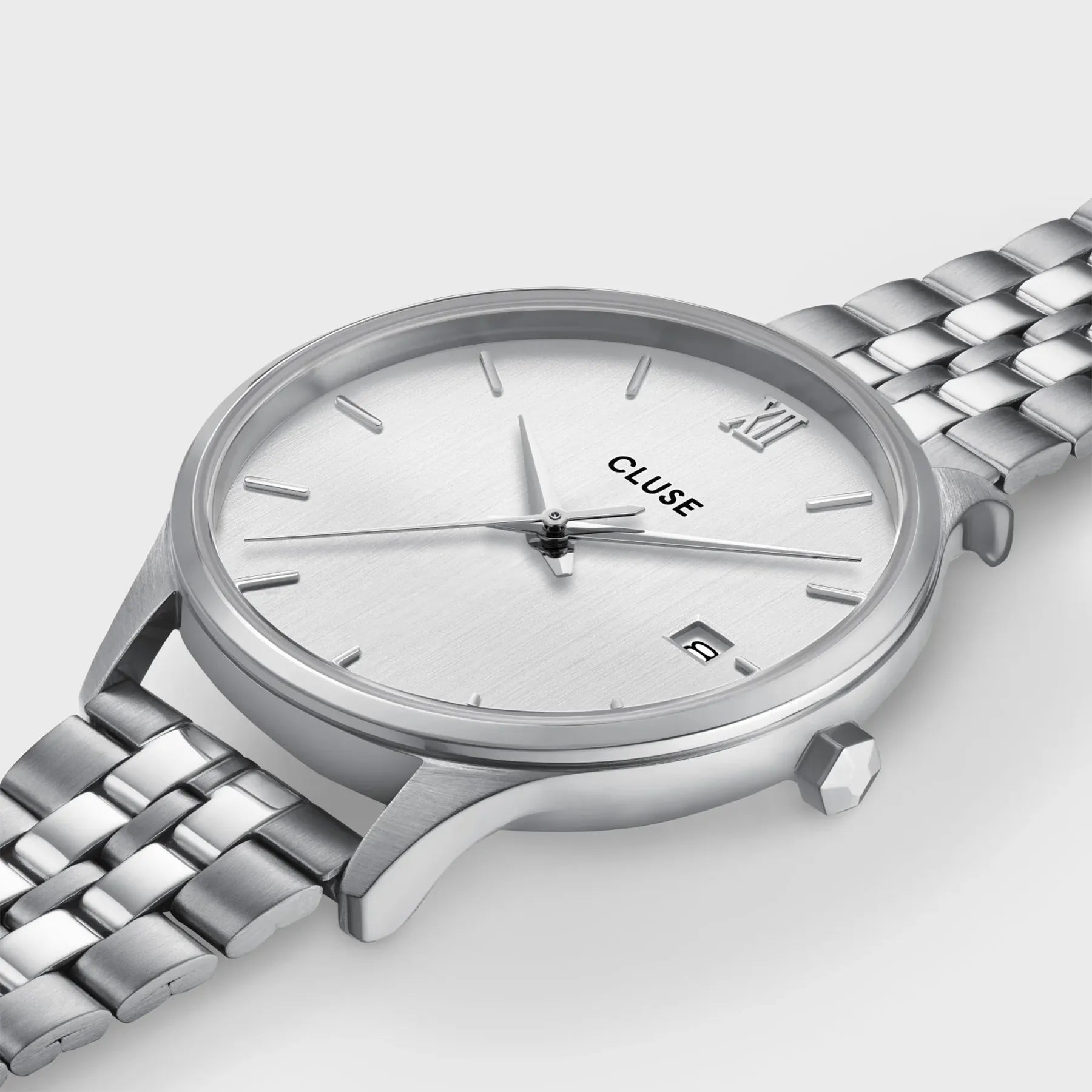 Leicht schräge Ansicht der silberfarbenen Cluse Damenuhr Minuit Date der Referenz CW14303 mit silbernem Zifferblatt an einem 5-gliedrigen Edelstahl-Armband