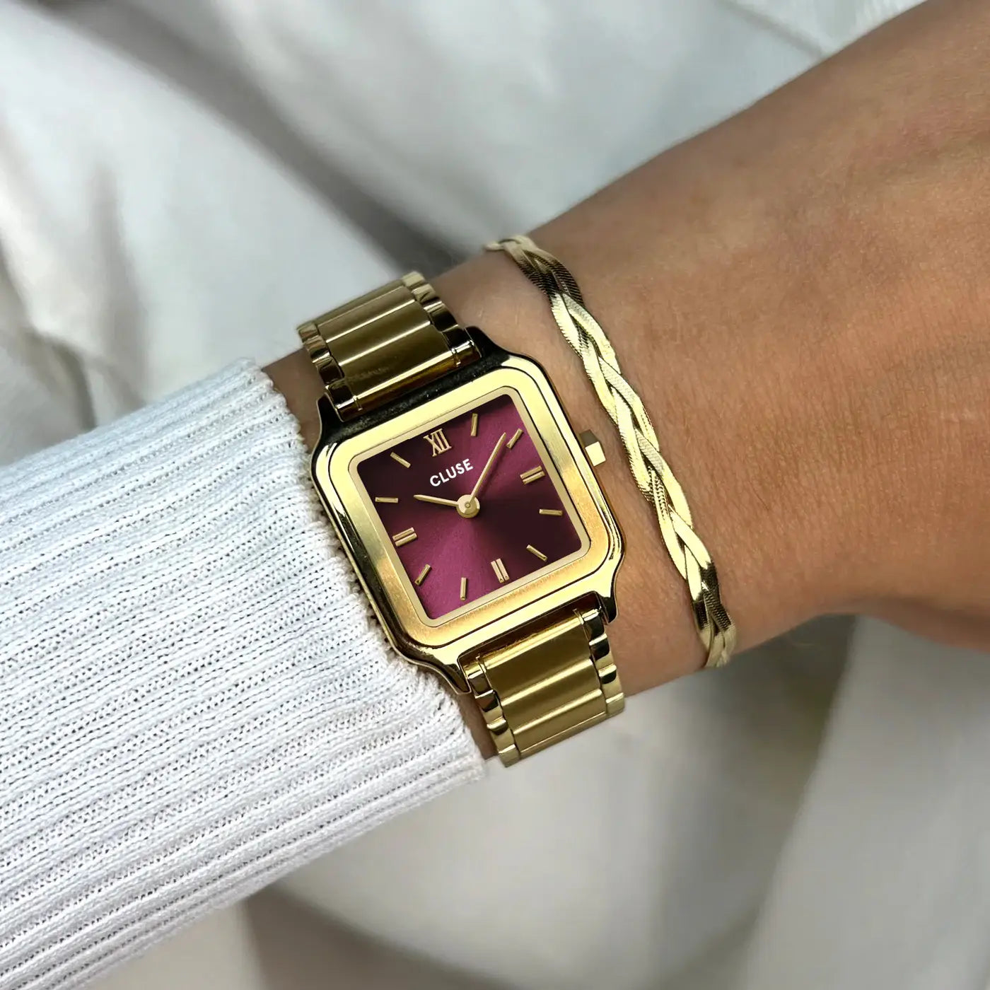 Wristshot mit der goldfarbenen Cluse Gracieuse Petite Damenuhr mit rechteckigem Gehäuse und dunkelrotem Zifferblatt