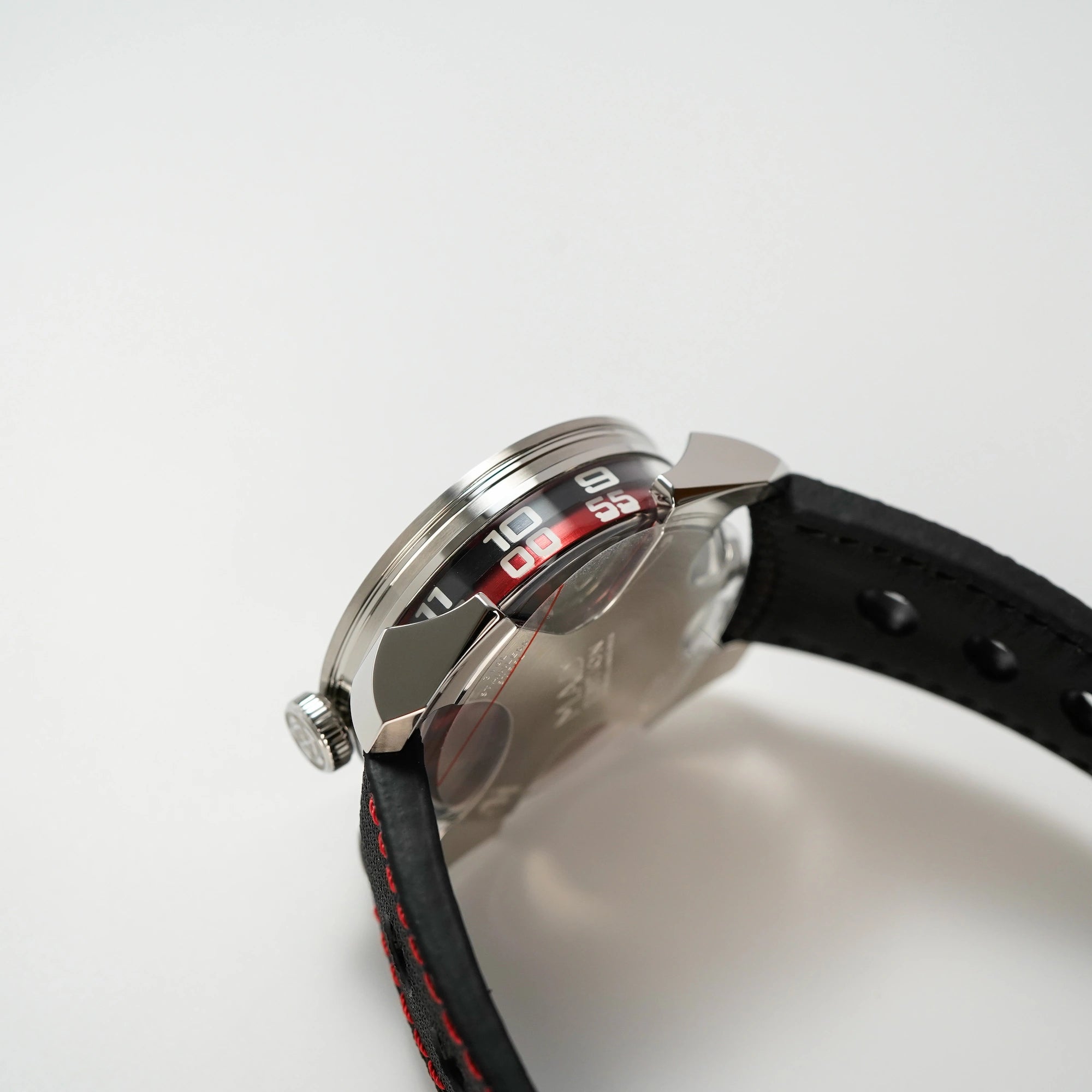 Seitlicher Blick auf das Gehäuse und Krone  der MB&F Mad 1 Red Edition mit einem schwarzen Zahlenring zur Stundenanzeige und einem roten Ring für Minuten
