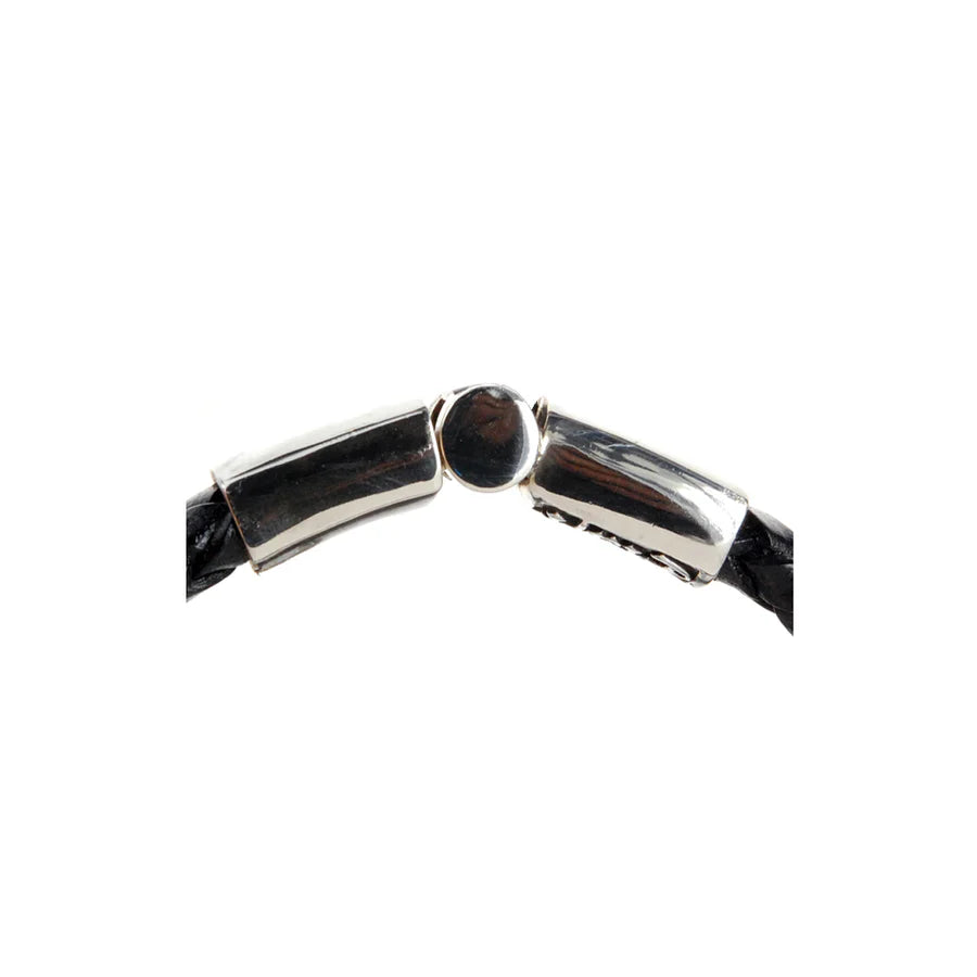 Detailaufnahme des Verschluss-Mechanismus des schwarzen, geflochtenen Lederarmbands mit glattem Silberverschluss  und einer zentralen Lielie als Design-Highlight des Verschlusses