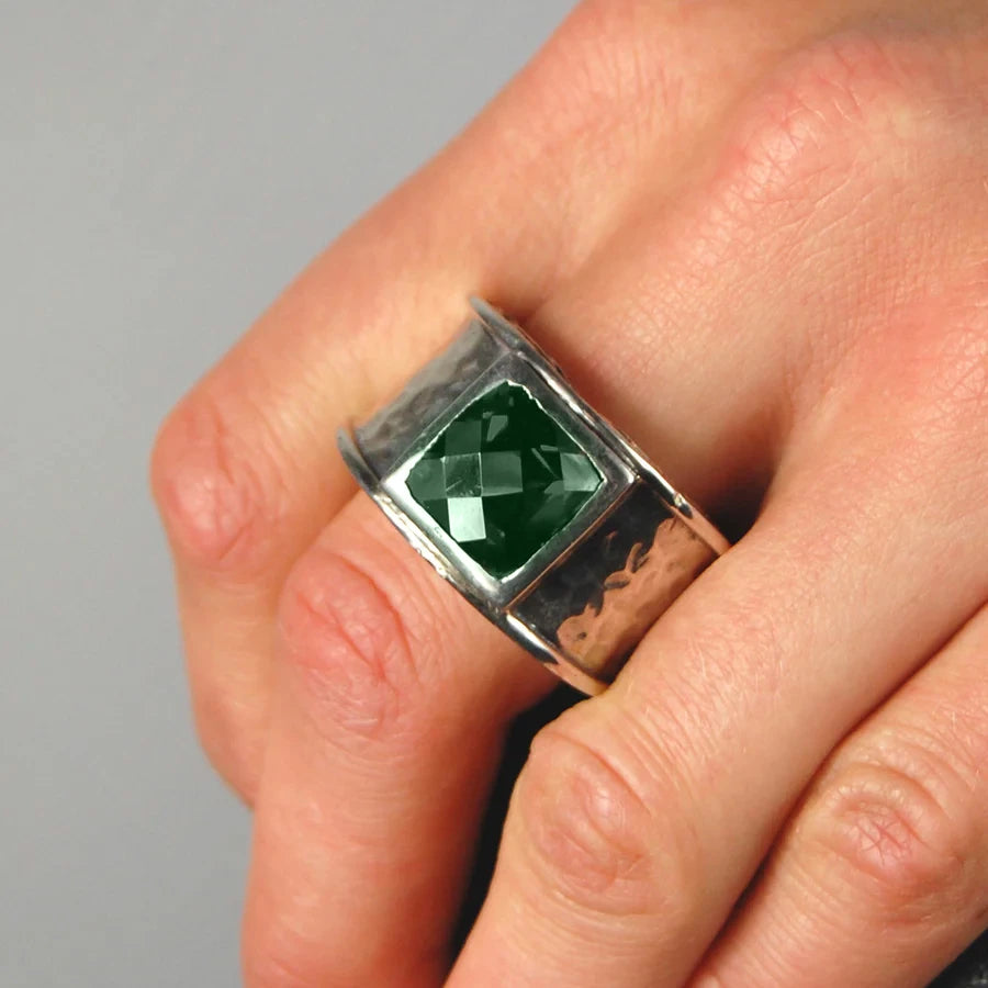 Mann trägt den Elfcraft Draon Fire Rings mit Hammerschlag und grünem, quadratischen Zirkonia-Stein, sowie einem Drachenschuppen-Design an der seitlichen Fläche