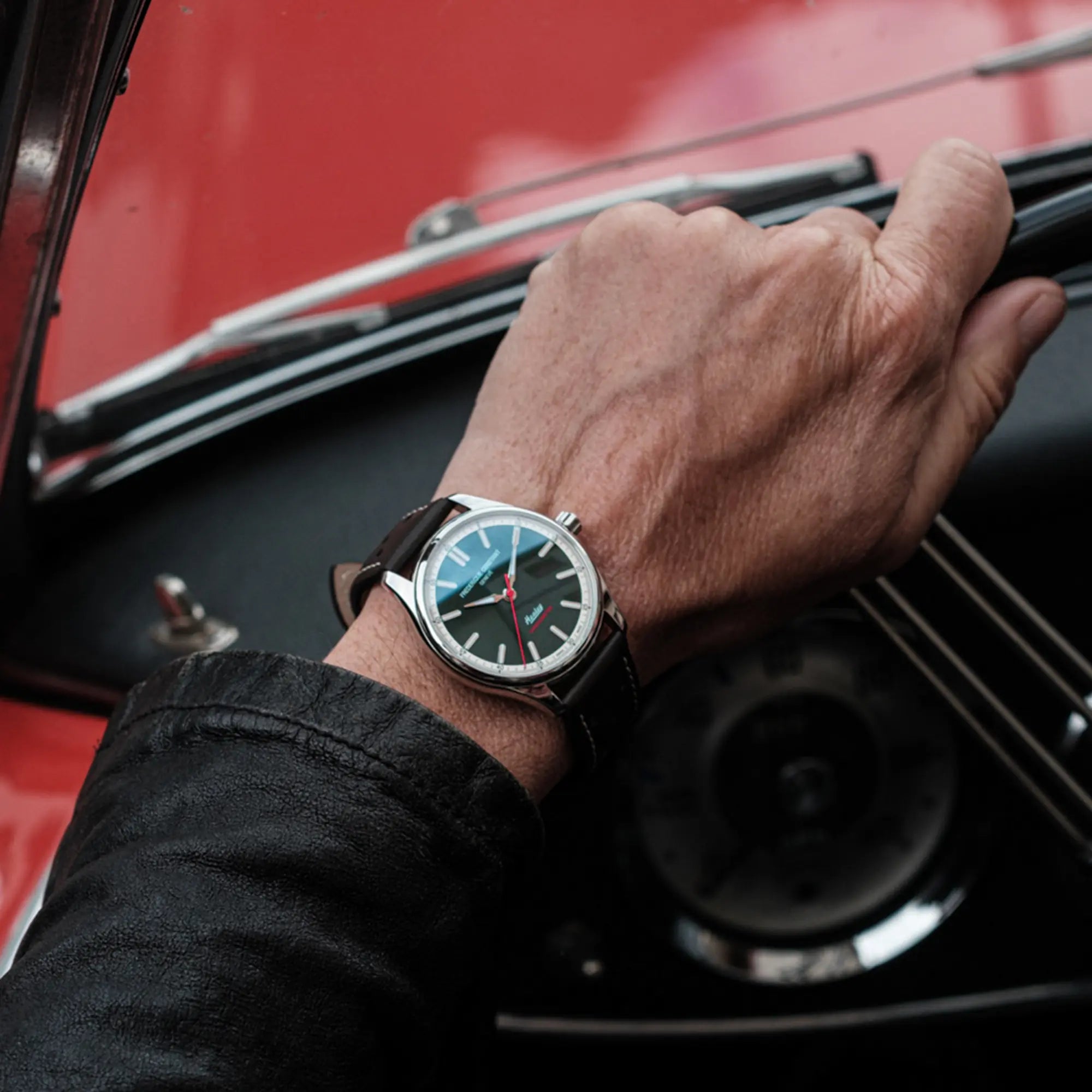 Mann trägt die "Vintage Rally Healey" Uhr von Frederique Constant aus der Classics Kollektion mit einem dunkelgrünem Zifferblatt und einem braunen Lederarmband im Racing-Look an seinem Handgelenk