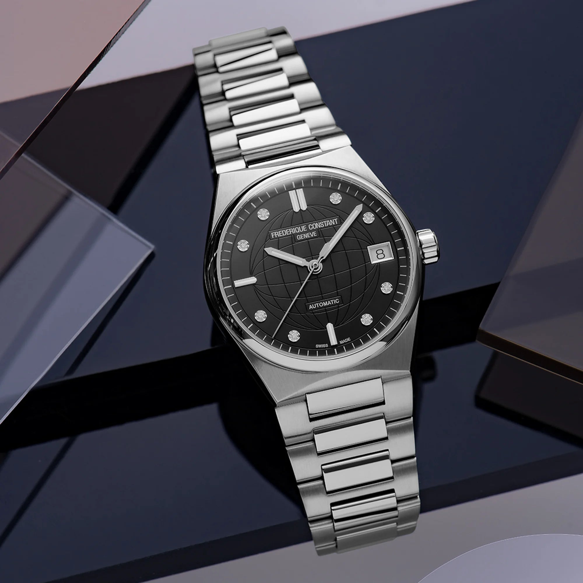 Produktfotografie der Frederique Constant Uhr "Highlife Ladies Automatic" mit einem schwarzen Zifferblatt mit Diamant-Indizes und Edelstahl-Gehäuse vor eckigen dunkelblauen Plastik-Scheiben