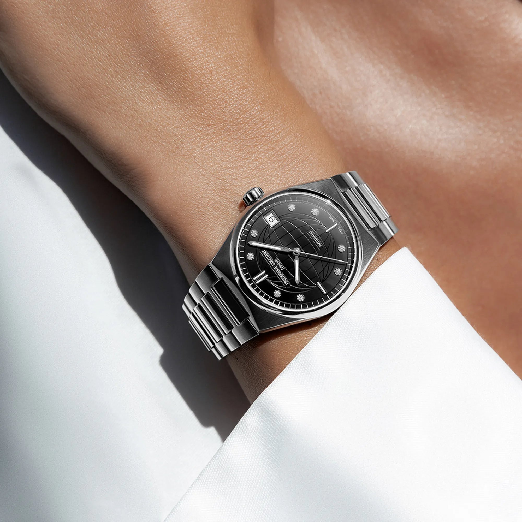 Frau trägt die Frederique Constant Uhr "Highlife Ladies Automatic" mit einem schwarzen Zifferblatt mit Diamant-Indizes und Edelstahl-Gehäuse an Ihrem Handgelenk
