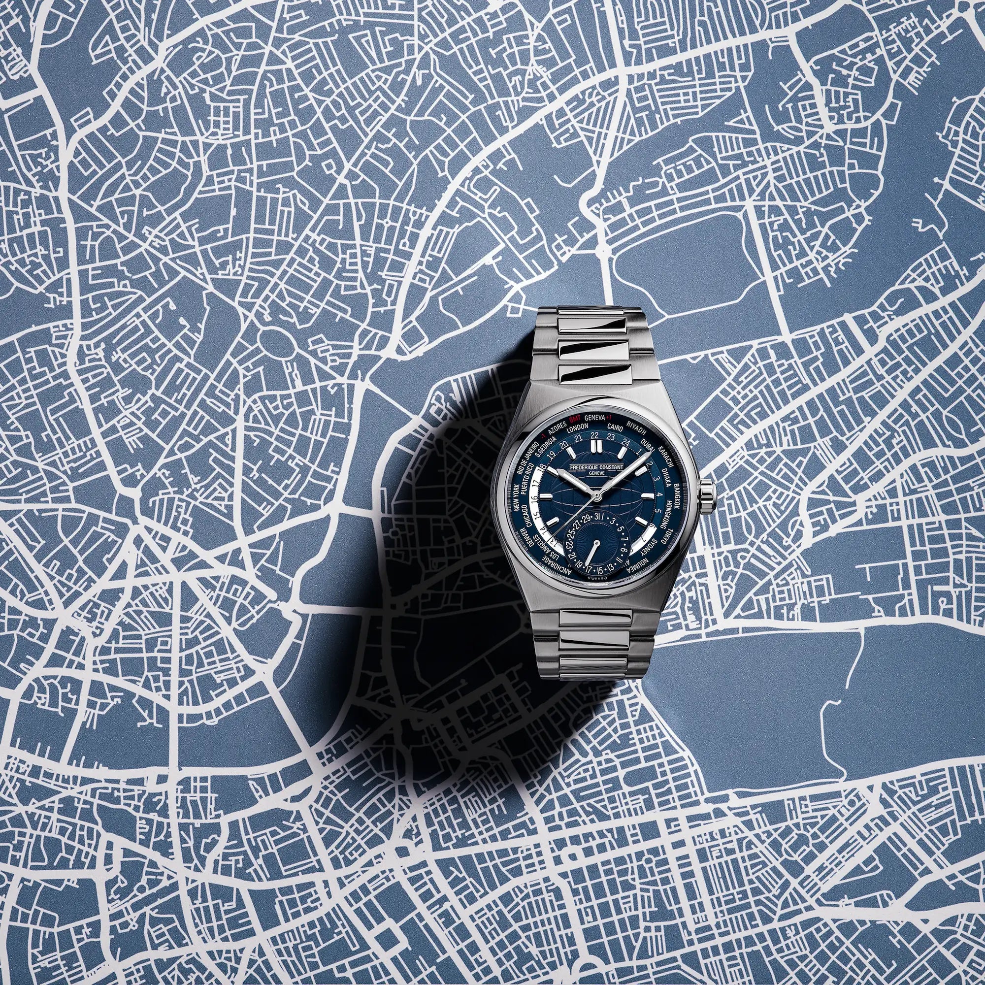 Produktfotografie der Worldtimer-Uhr von Frederique Constant aus der Highlife Kollektion mit einem blauen Zifferblatt, das verschiedene Städte und deren Zeitzonen zeigen kann