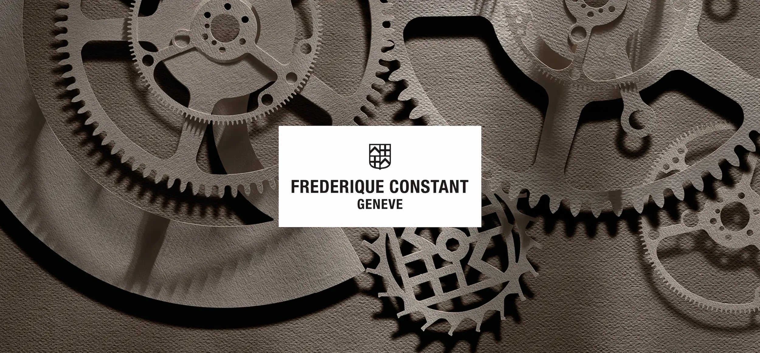 Markenpräsentation des Herstellers Frederique Constant mit Logo auf einer Darstellung eines Uhrwerks in Papier