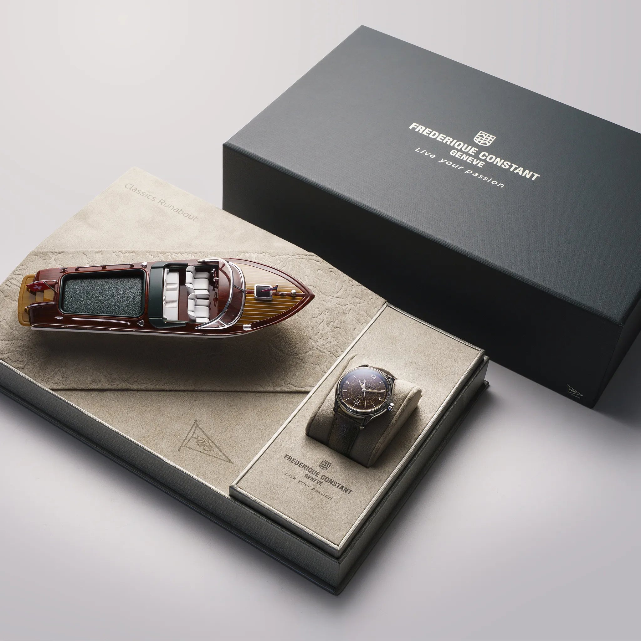 Frederique Constant Runabout GMT Herrenuhr FC-350RN5B6 mit 42mm Edelstahl-Gehäuse, tiefblauem Zifferblatt mit Indizes im beigen Vintage-Look am schwarzen Kautschuk-Armband zusammen mit der besonderen Uhrenbox, bei der ein Mini-Replik eines Runabout Bootes mit inbegriffen ist