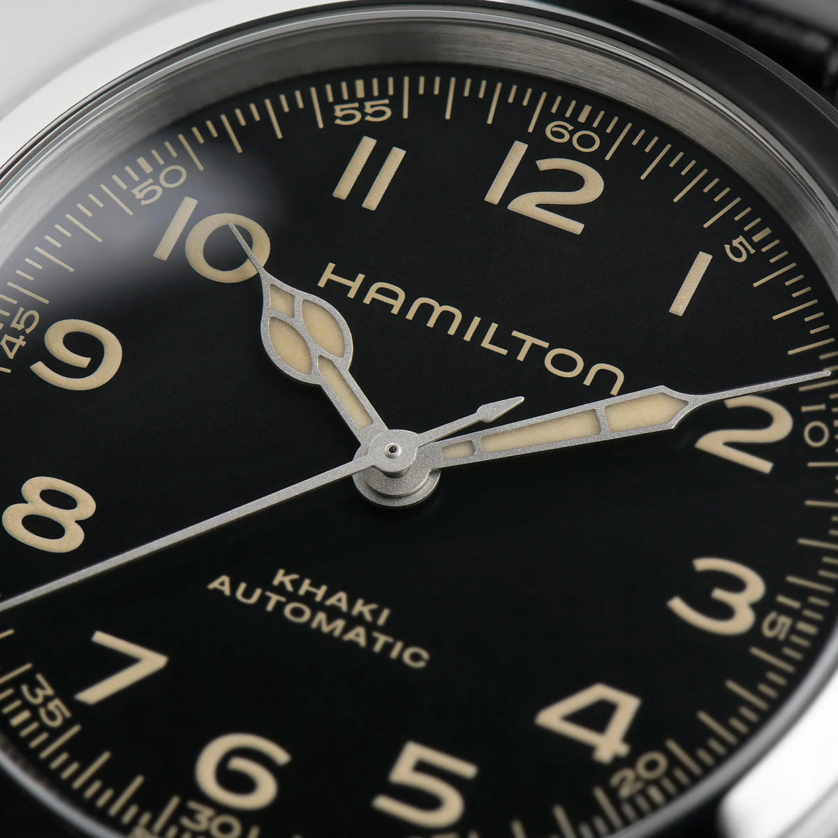 Detailaufnahme mit Fokus auf dem Zeigersatz der Hamilton Murph H70405730 im 38mm-Edelstahl-Gehäuse und einem schwarzem Zifferblatt Indizes und Zeigern mit Vintage-Charakter