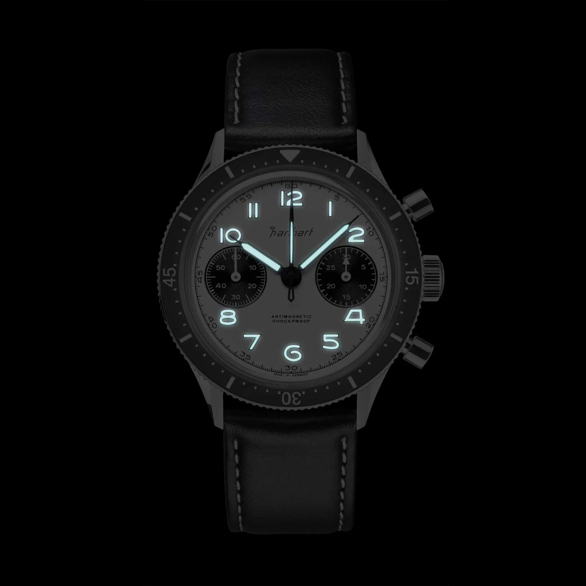 Hanhart 415 ES Chronographs mit dem Panda-Zifferblatt in Weiß mit schwarzen Sub-Dials bei Dunkelheit mot funktionierender Leuchtmasse auf Ziegern und Indizes