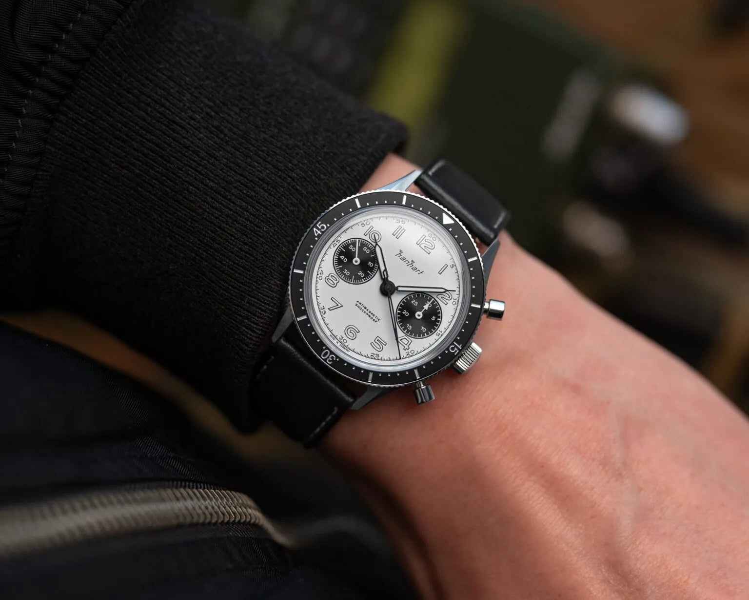 Mann trägt den Hanhart 415 ES Chronographs mit dem Panda-Zifferblatt in Weiß mit schwarzen Sub-Dials am Arm