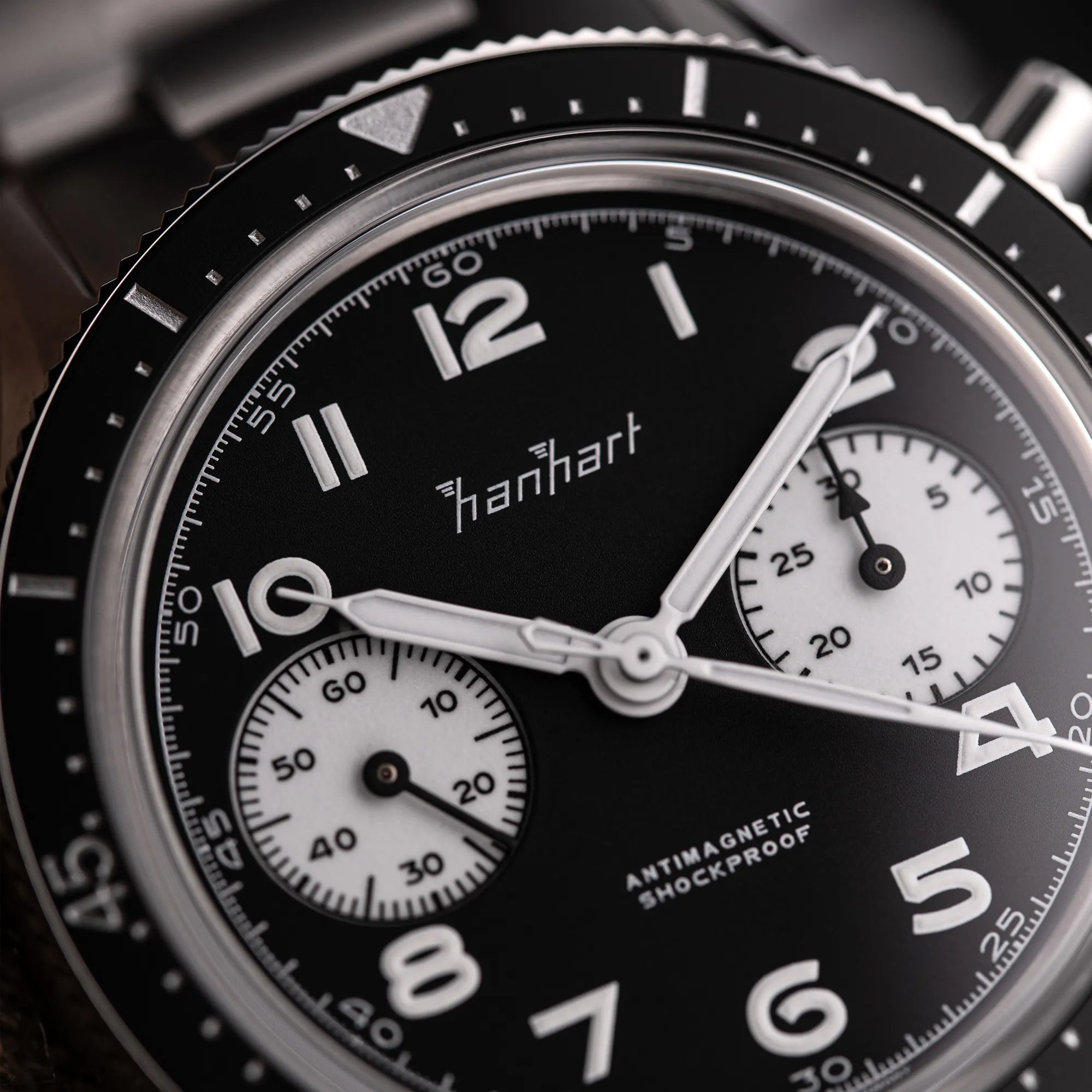 Detailaufnahme des Hanhart 415 ES Chronographs mit dem Reverse-Panda-Zifferblatt in Schwarz mit weißen Sub-Dials am Edelstahlarmband
