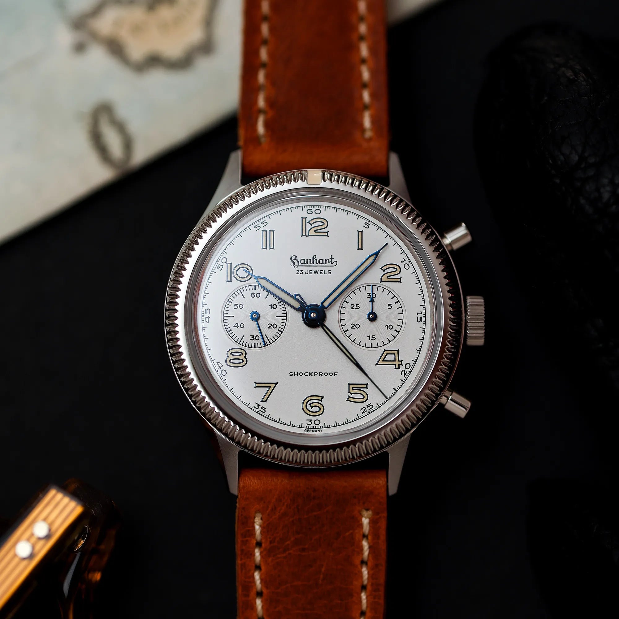 Produktfotografie der Hanhart 417 ES "Moby Dick" Chronographs mit 42mm-Gehäuse und weißem Zifferblatt am hellbraunen Lederband