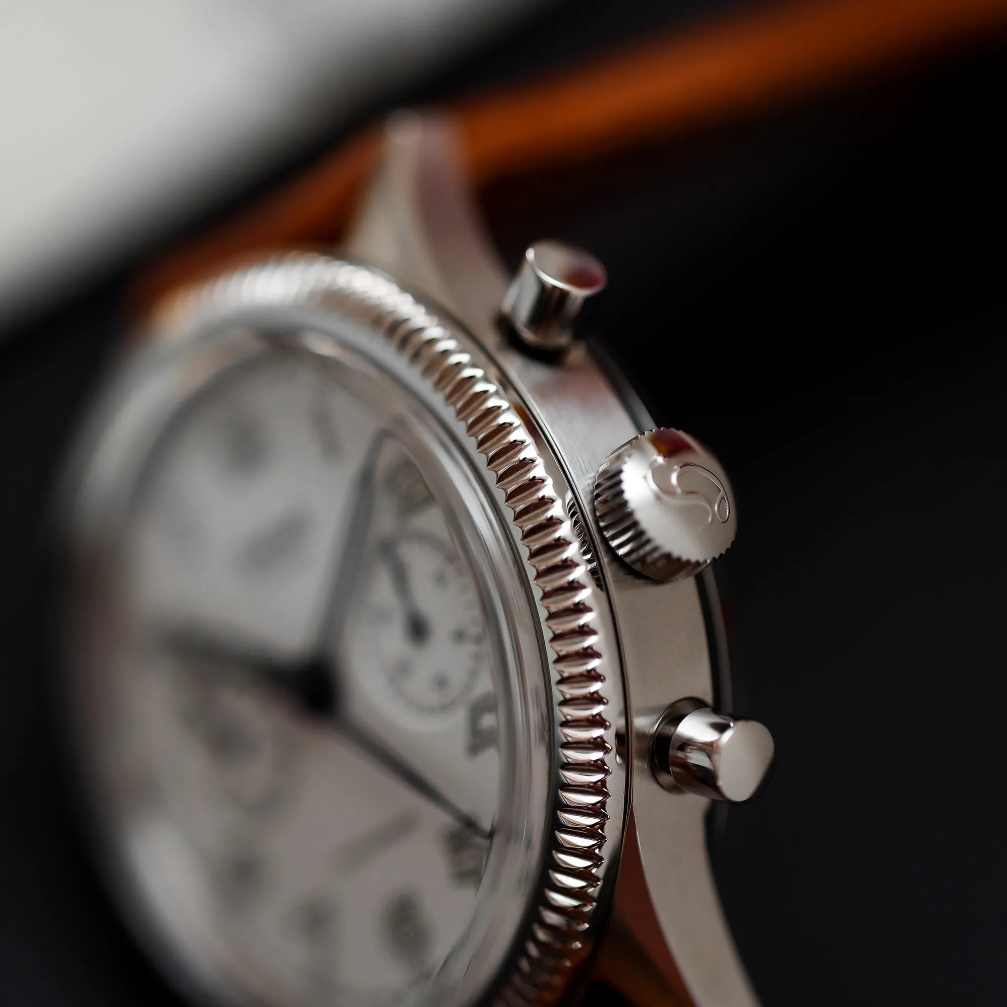 Detailfotografie der kannelierten Lünette von dem Hanhart 417 ES "Moby Dick" Chronograph mit 42mm-Gehäuse und weißem Zifferblatt am hellbraunen Lederband